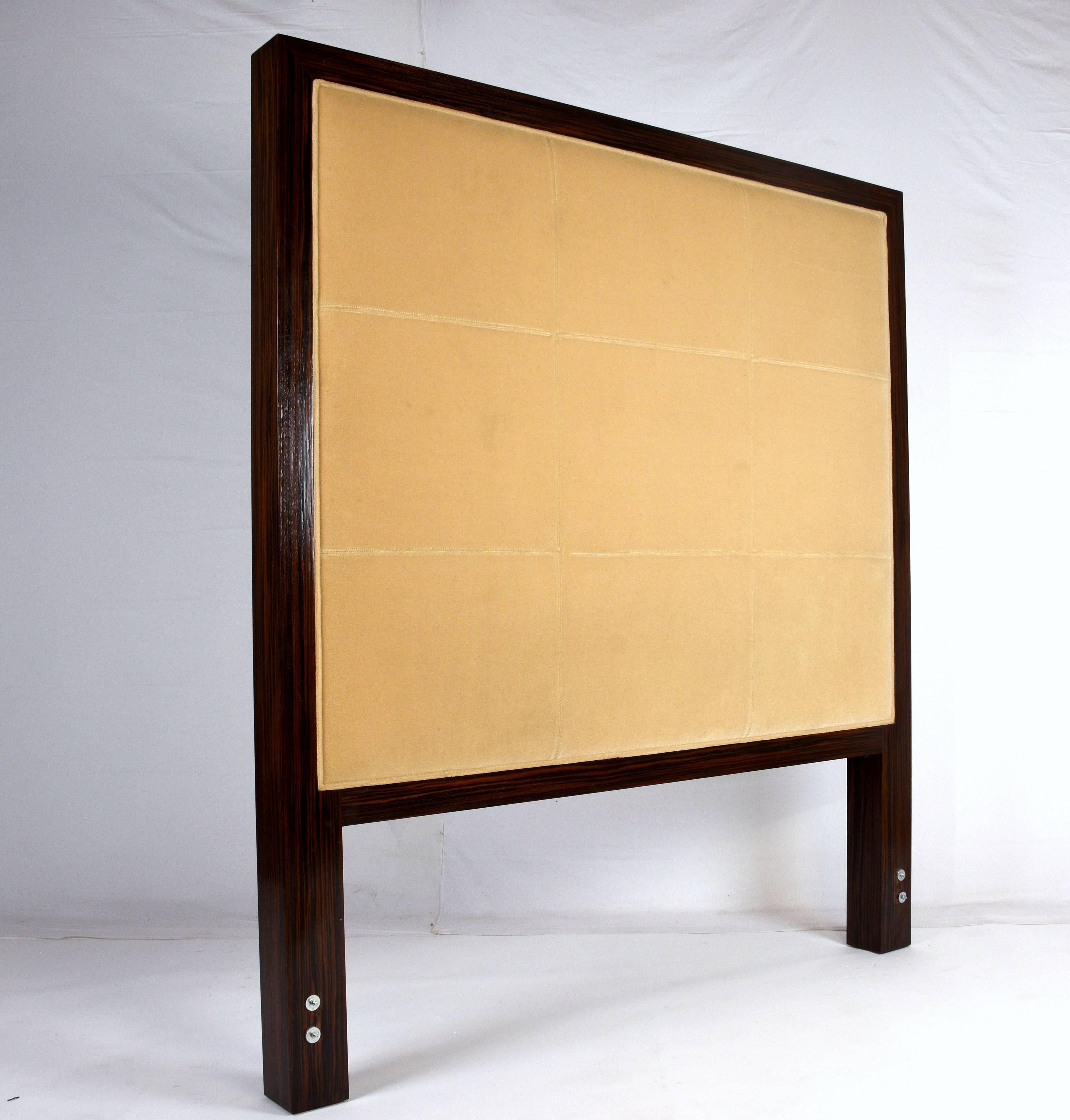 This 1990s Modern-style king-size headboard is made from wood covered in Macassar veneers. The beautiful veneer is stained in a rich mahogany color with a lacquer finish. The front of the headboard is upholstered in a mohair fabric with a unique