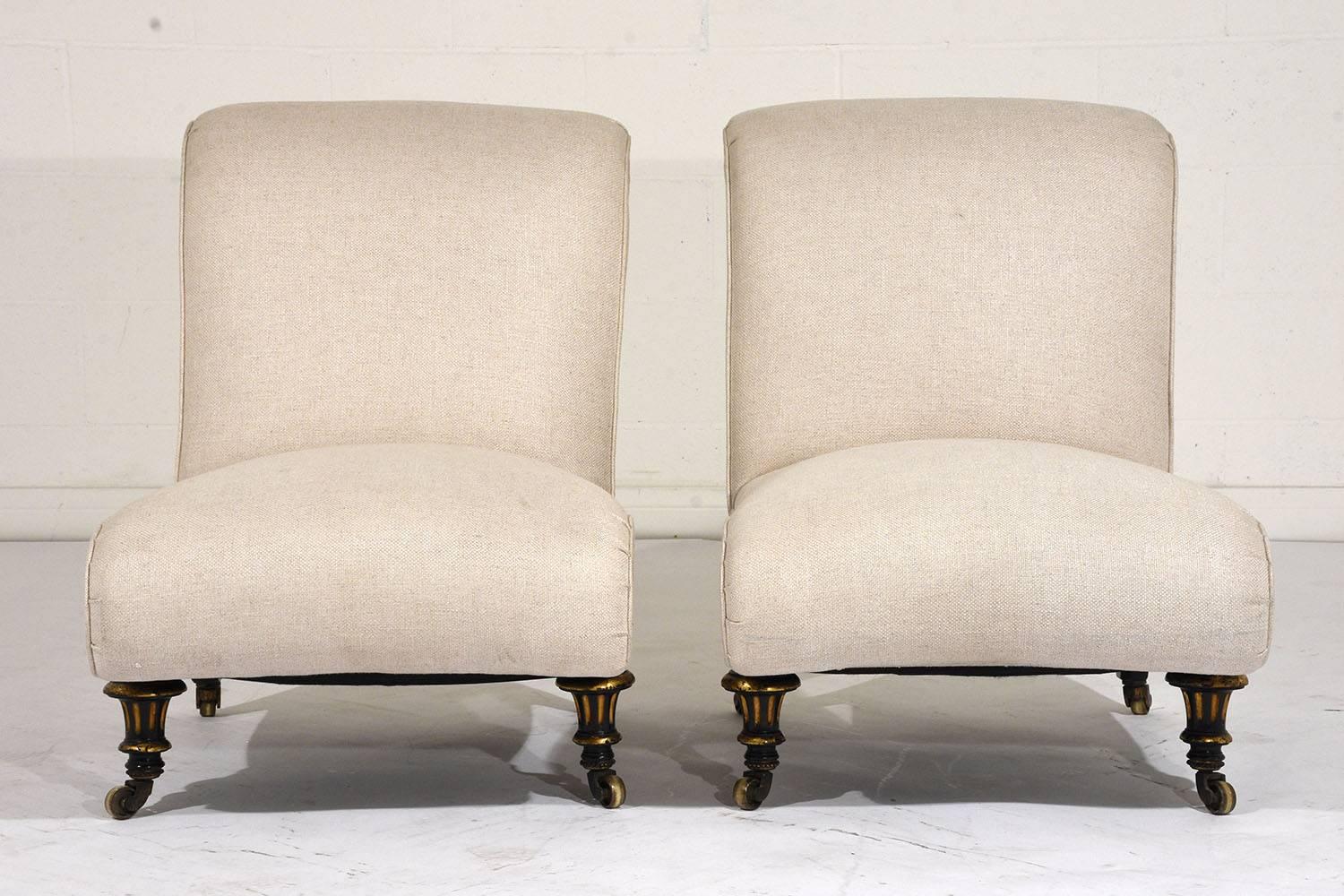 This pair of 1900s antique French Regency-style slipper chairs feature wood frames that feature an ebonized and lacquered finish. The beautiful curved frame has scroll details on the back and at the front. The delicate moulding details have gild