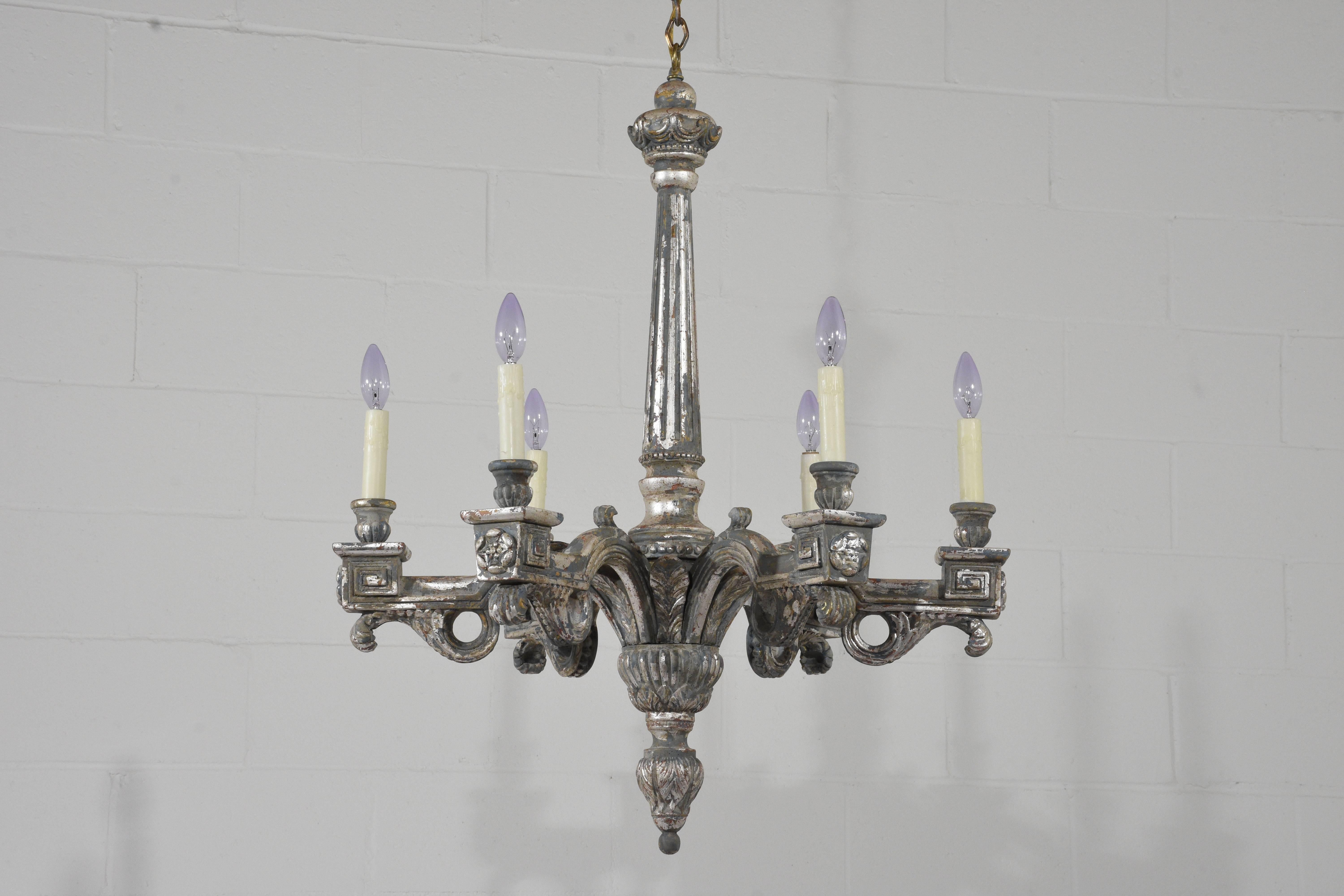 This pair of 1950s Italian Neoclassical-style chandeliers are made of wood that has been painted in a gray, red and off-white color combination with silver leaf accents and a beautiful distressed finish. The six arms are adorned with carved details