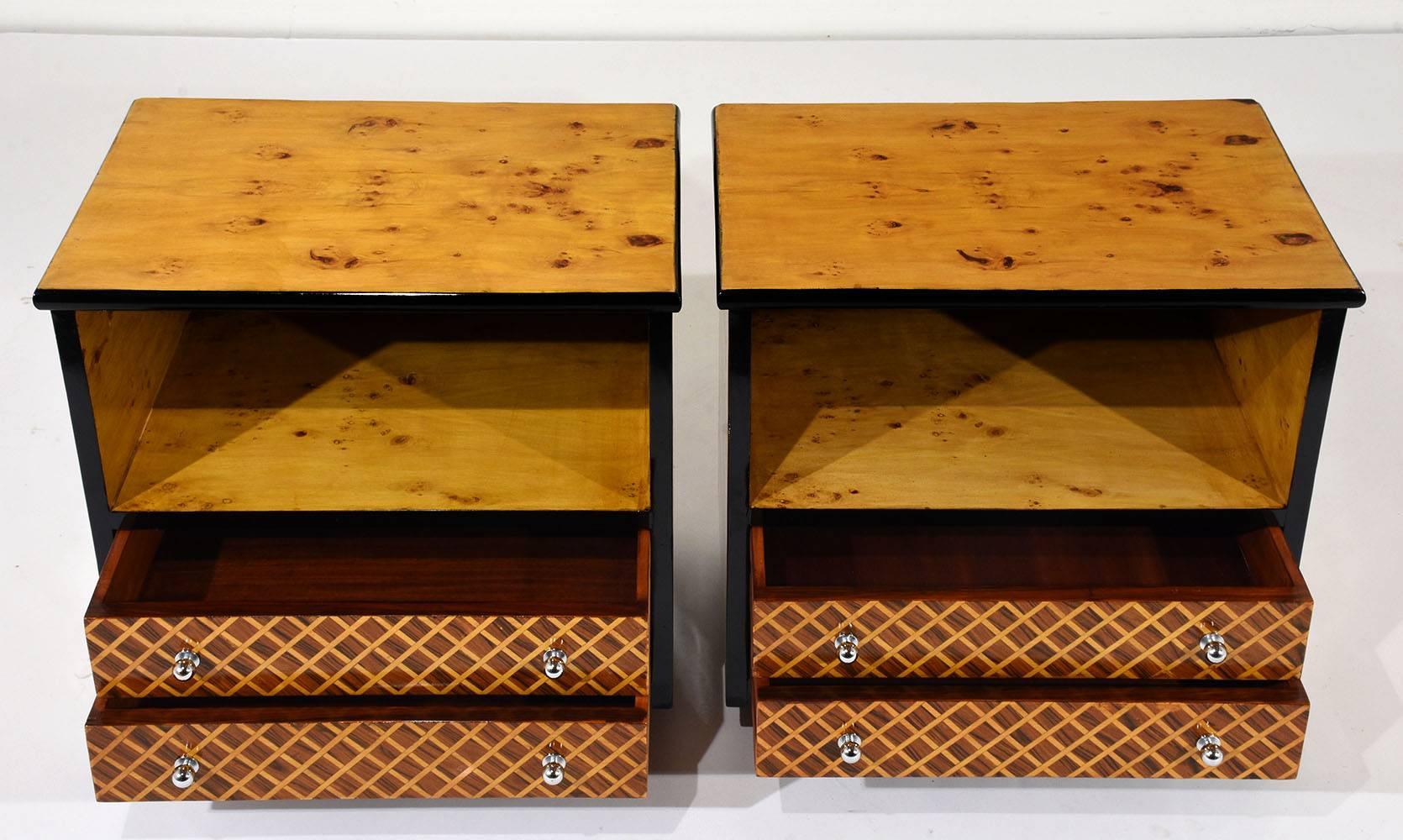 This pair of Mid-Century Modern-style nightstands or side tables is made of wood covered in burl veneers finished in beautiful golden oak color stain with black accents. The two drawers are uniquely adorned with a crisscross marquetry pattern and