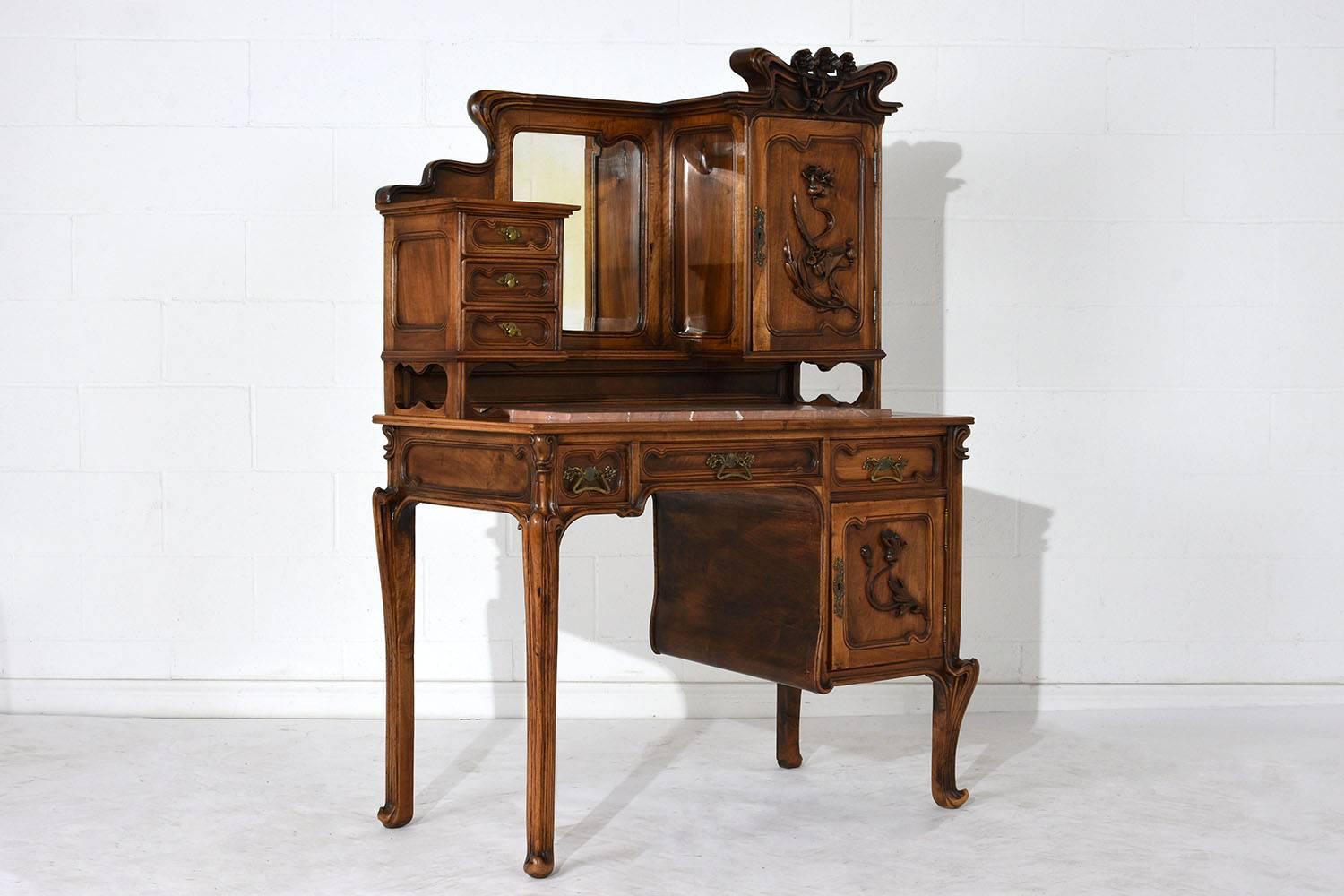 This Exquisite 1900s Art Nouveau Desk is made in the manner of Louis Majorelle and is made of walnut wood in its original walnut color stain and has recently been waxed/polished giving it a lovely patina finish. This desk features the original