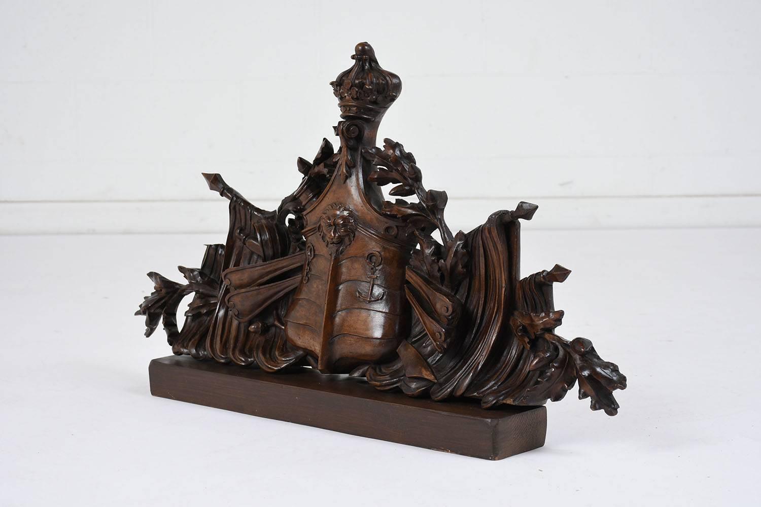 This 1820s French Louis XVI-style pediment is made of walnut wood stained in a deep walnut color with a polished finish. The intricately carved pediment depicts a naval ship with a lion's head on the bow and a crown at the top of the mast and oars