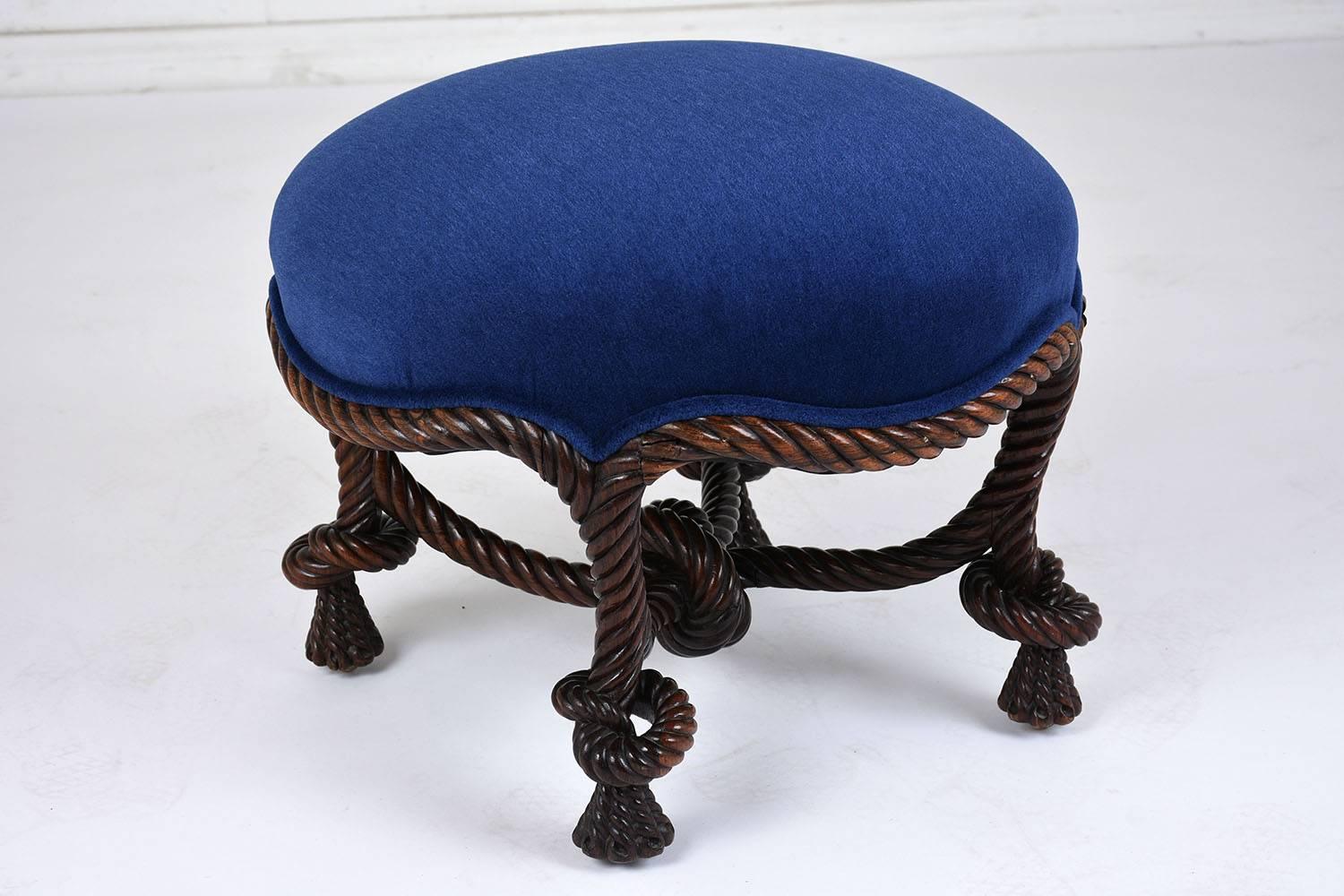 This 1850's Louis XVI-style ottoman or foot stool features a walnut wood frame stained in a deep walnut color. The frame is adorned with stunning braided rope carvings. The stool has recently been professionally upholstered in a royal blue mohair