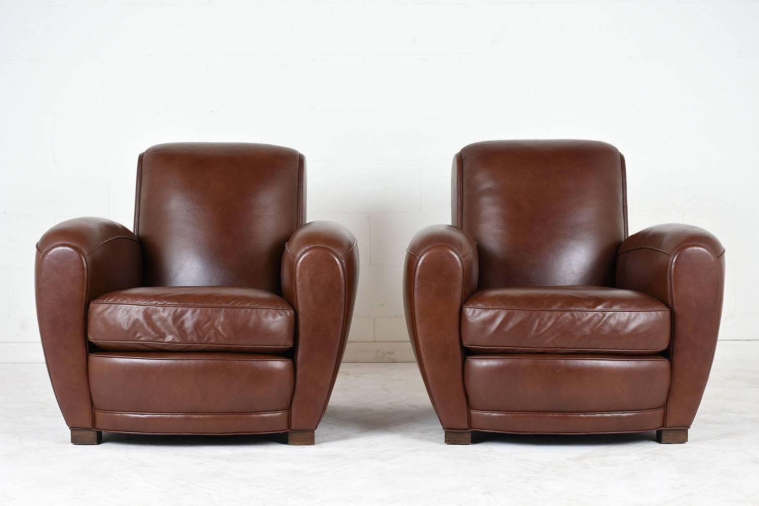 This Pair of 1950's Art-Deco Club Chairs are in very good condition, features its original brown leather upholstery with single piping trim details and brass nailhead trim along the back. The chairs each have a single removable seat cushion with