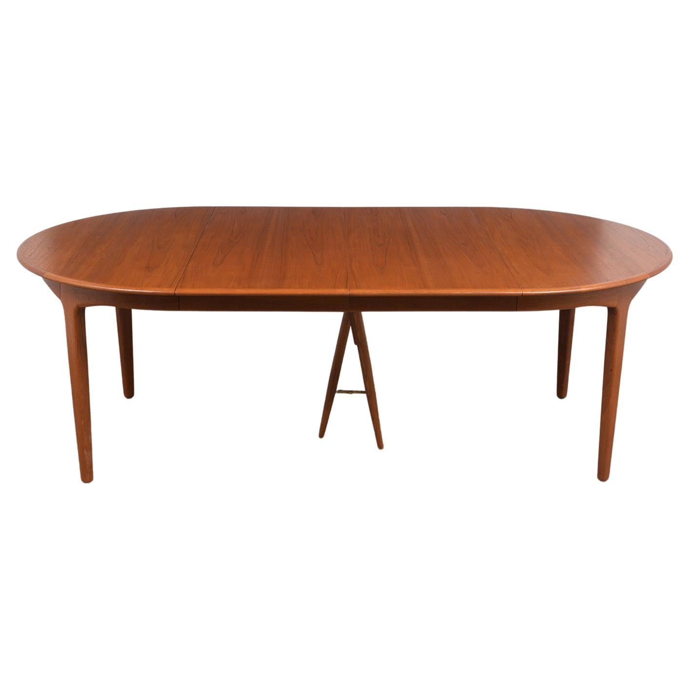 This large Henning Kjaernulf for Soro Stolefabrik Danish dining table is made out of teak wood with its original walnut-stained finish and has been restored by our team of craftsmen. This round table comes with three extra leaves that can be added/