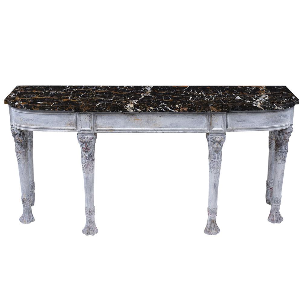 This Vintage French Empire Console is made out of mahogany wood features a thick black and gold marble top in great condition and has been newly restored. The marble top rests on a sturdy frame raised by six legs with lion faces and claw feet carved
