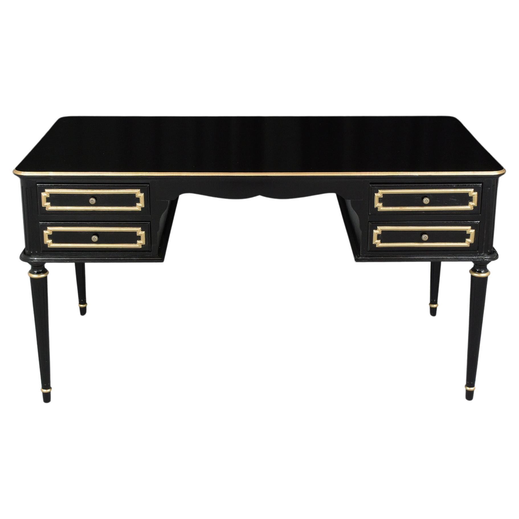 An extraordinary early 1950s Louis XVI gilt desk is hand-crafted out of solid wood in great condition and has been completely restored by our professional craftsmen team. This lovely desk features an elegant ebonized color stain with a newly