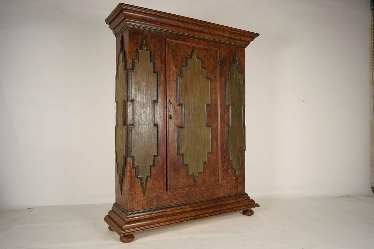 This 1880's Baroque Style Single Door Armoire is made from solid wood with its original multi-color finish and waxed patina finish. The armoire features a large crown and base molding on the top and bottom and on the sides and front, there is