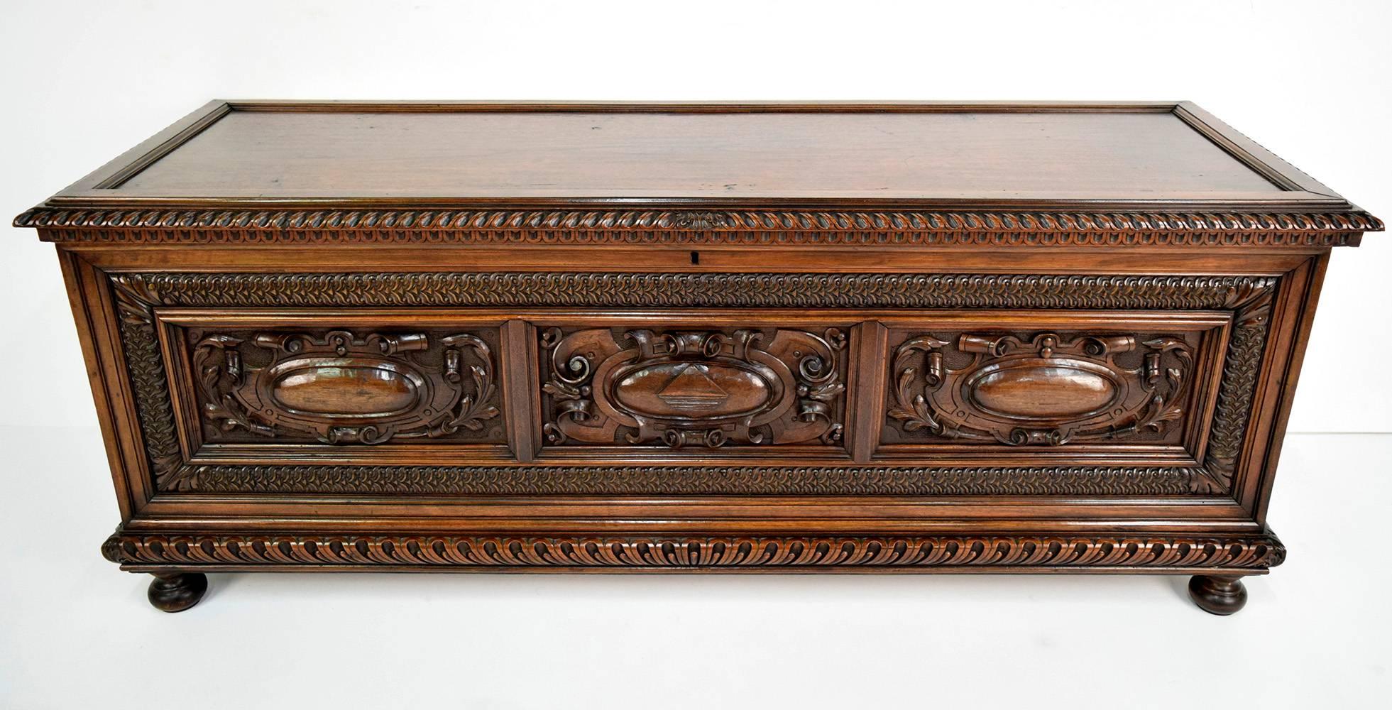 This one of a kind 1830's Antique Renaissance-style trunk or chest is made of solid walnut wood with its original walnut finish. There are stunning hand carved decorations on the front and on the top and sides. The chest is adorned with its original