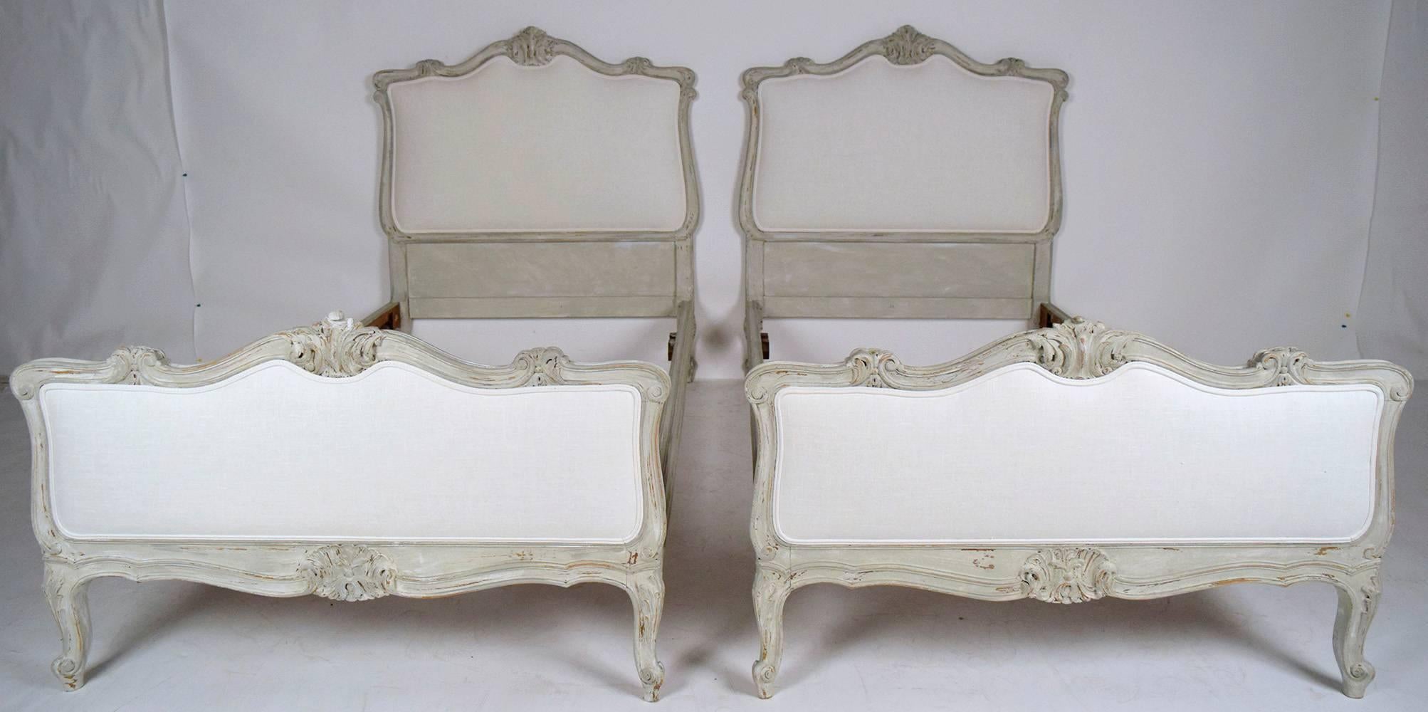 This lovely pair of 1900's French Louis XV-style bed frames are made from solid walnut wood with elegant carvings on the headboard, foot-board and legs. The frames have been recently painted in a pale gray color with a distressed finish. The