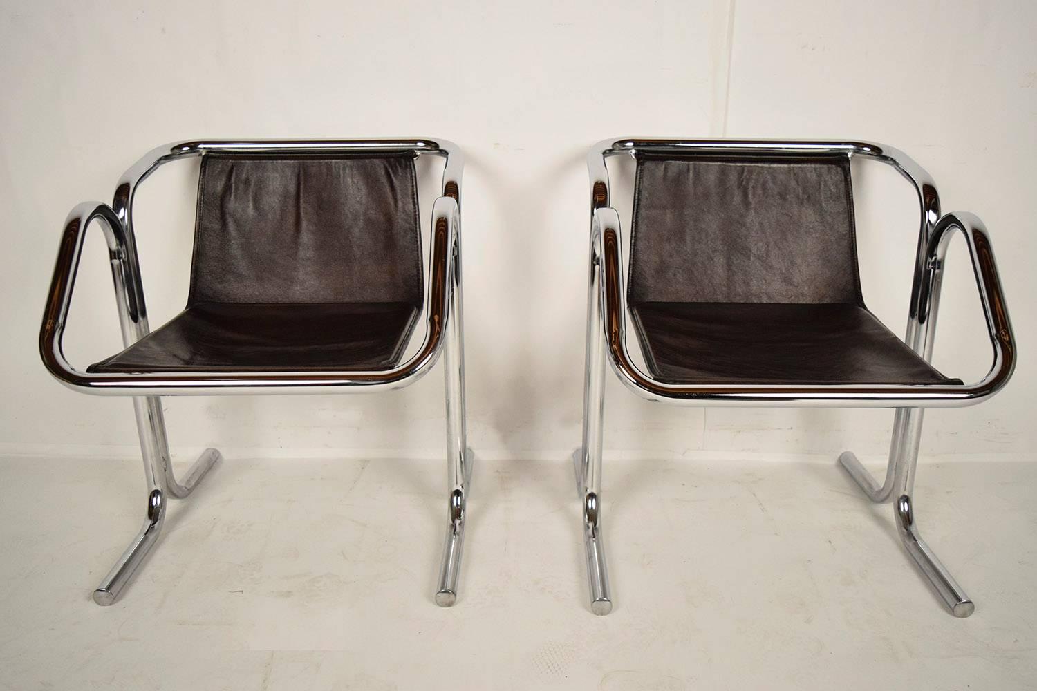 Pair of 1960s Jerry Johnson arcadia lounge chairs. Each chair features a chrome tubular frame and distressed black-leather slings. The frame is made of two pieces of chrome tube which have been fused together. The chrome is beautiful with incredible