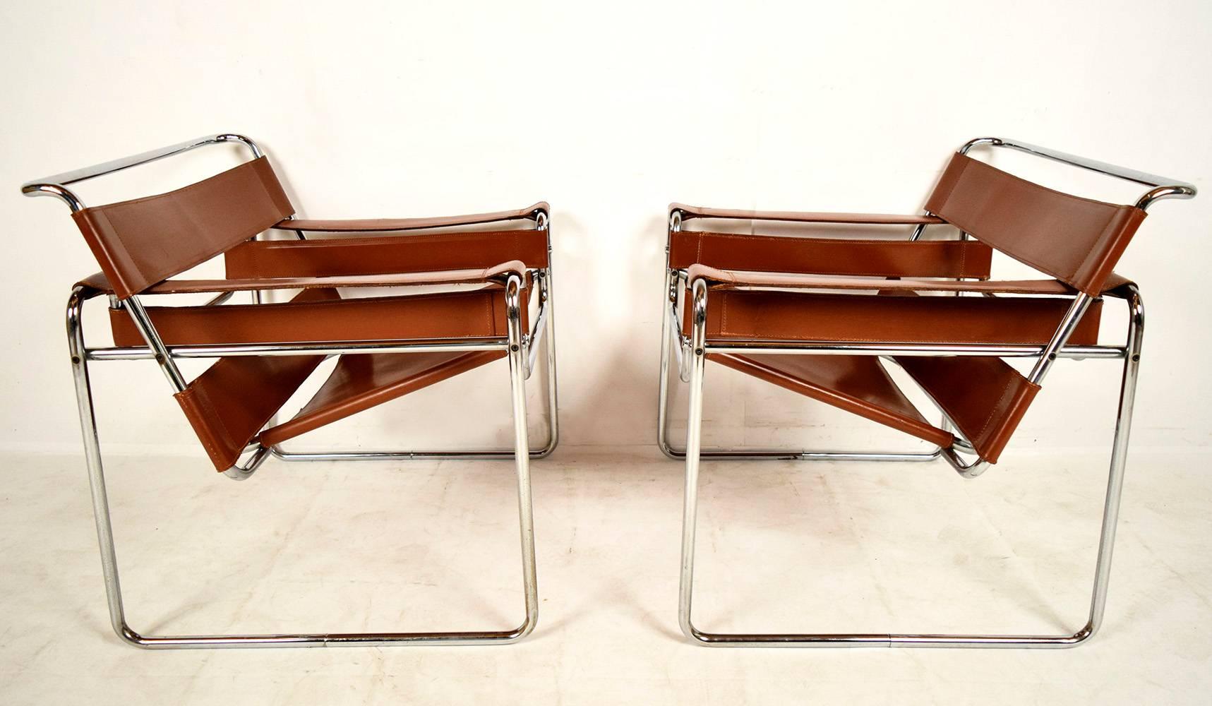 Pair of wassily lounge chairs designed by Marcel Breuer. Solid steel chrome frame, with stitched saddle color leather seat, back and arms. Chairs are solid and sturdy ready to be used. 
Arm height 23