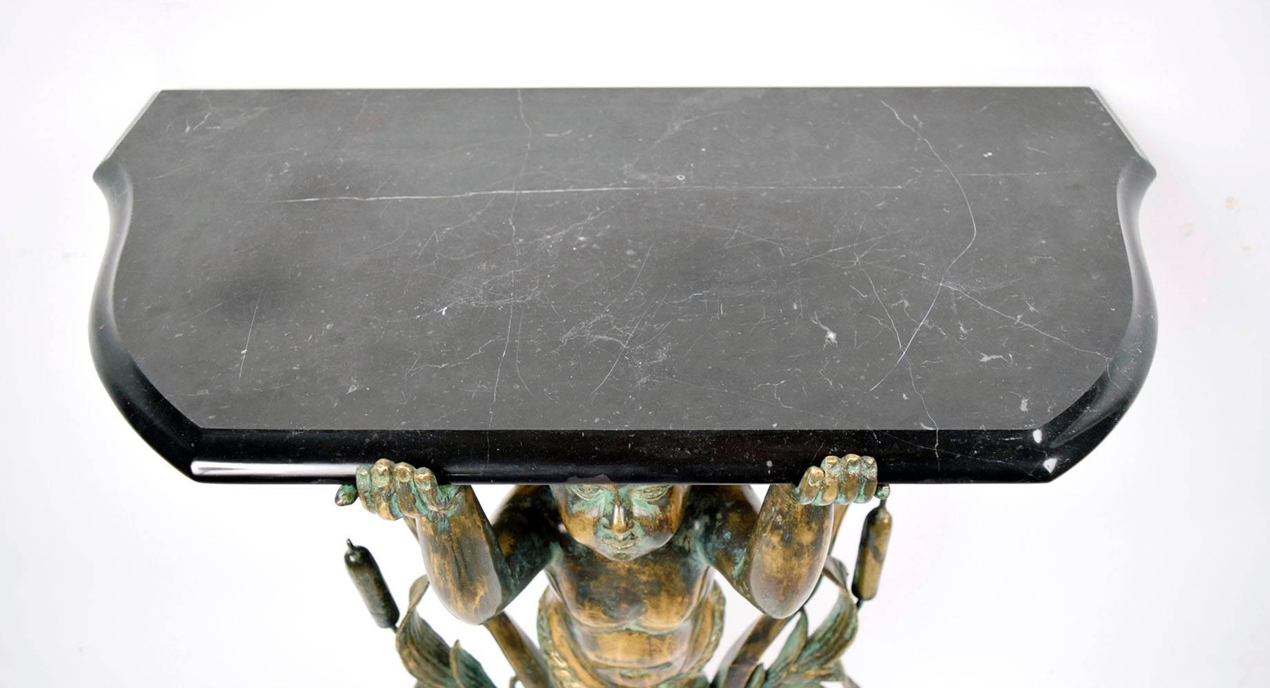 Pair of 1970s bronze side tables. Solid bronze statues, of an Cherub with Cattails on the sides and scrolls on the top holding a beveled black marble-top. Elegant bronze color with amazing patina, on a double circular marble base. Both side table