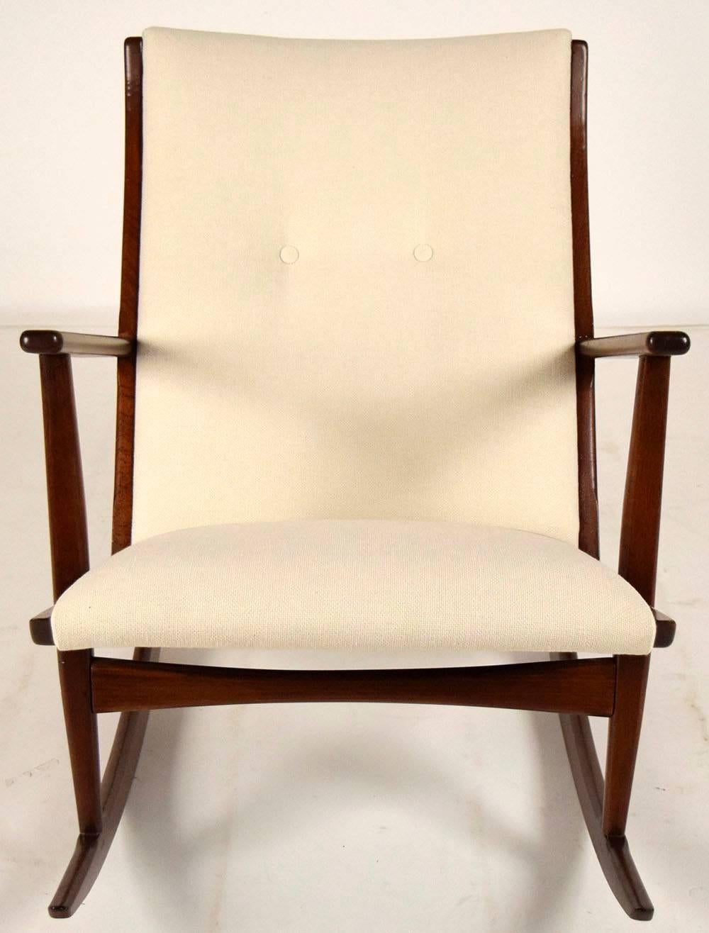Boomerang rocking chair 1960s by Soren Georg Jensen for Kubus. Beautiful teak wood frame, finished in a dark walnut color. Chair has been professionally upholstered in an ivory color fabric with two center buttons on the back. Chair is solid and