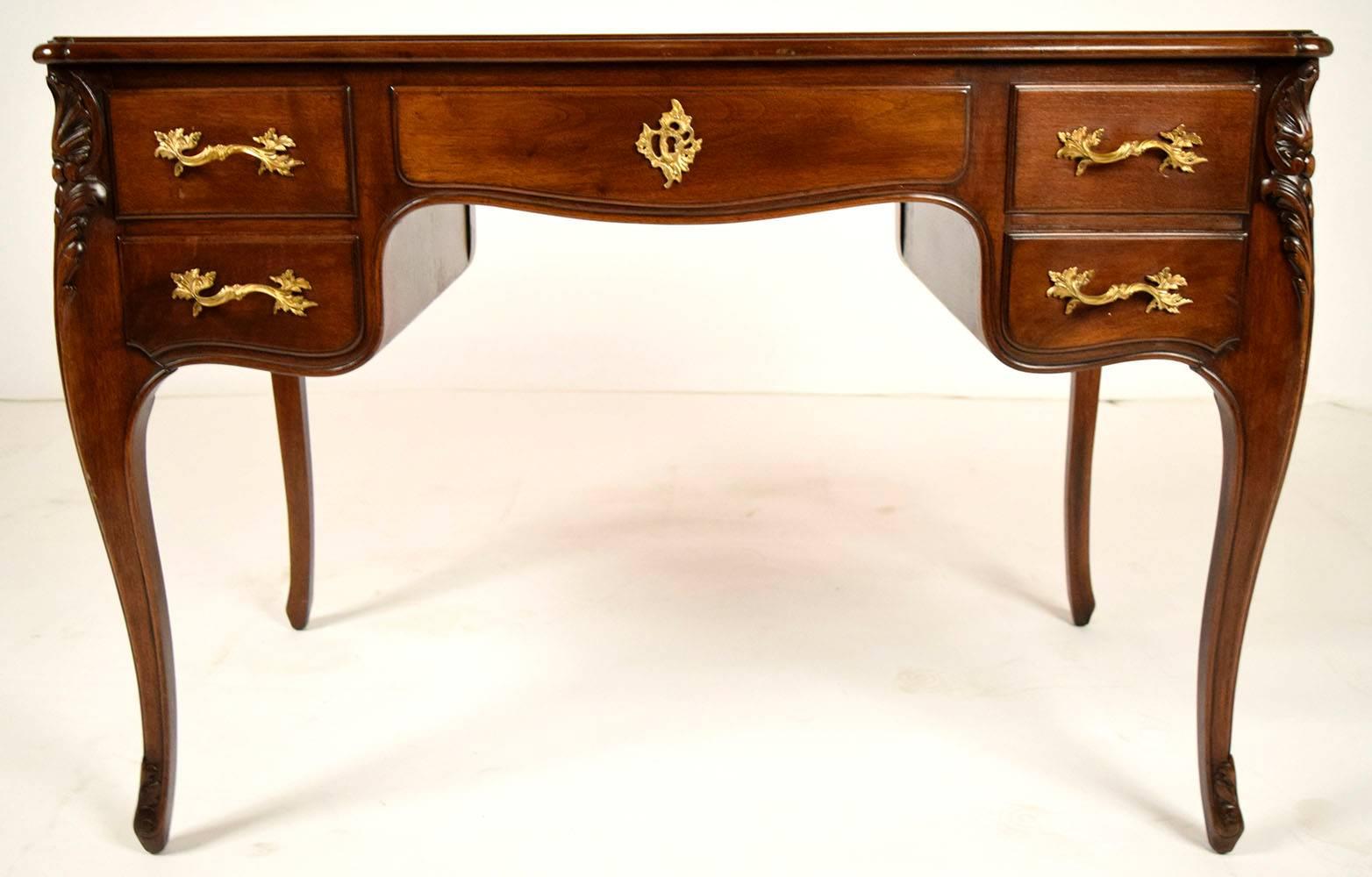 Beautiful 1900s Louis XV Desk. Made from solid walnut wood, with original walnut color finish. Top has original leather top in a distressed finish. Elegant corner carvings of shells and leafs the run down to the end of the serpentine leg. Has five