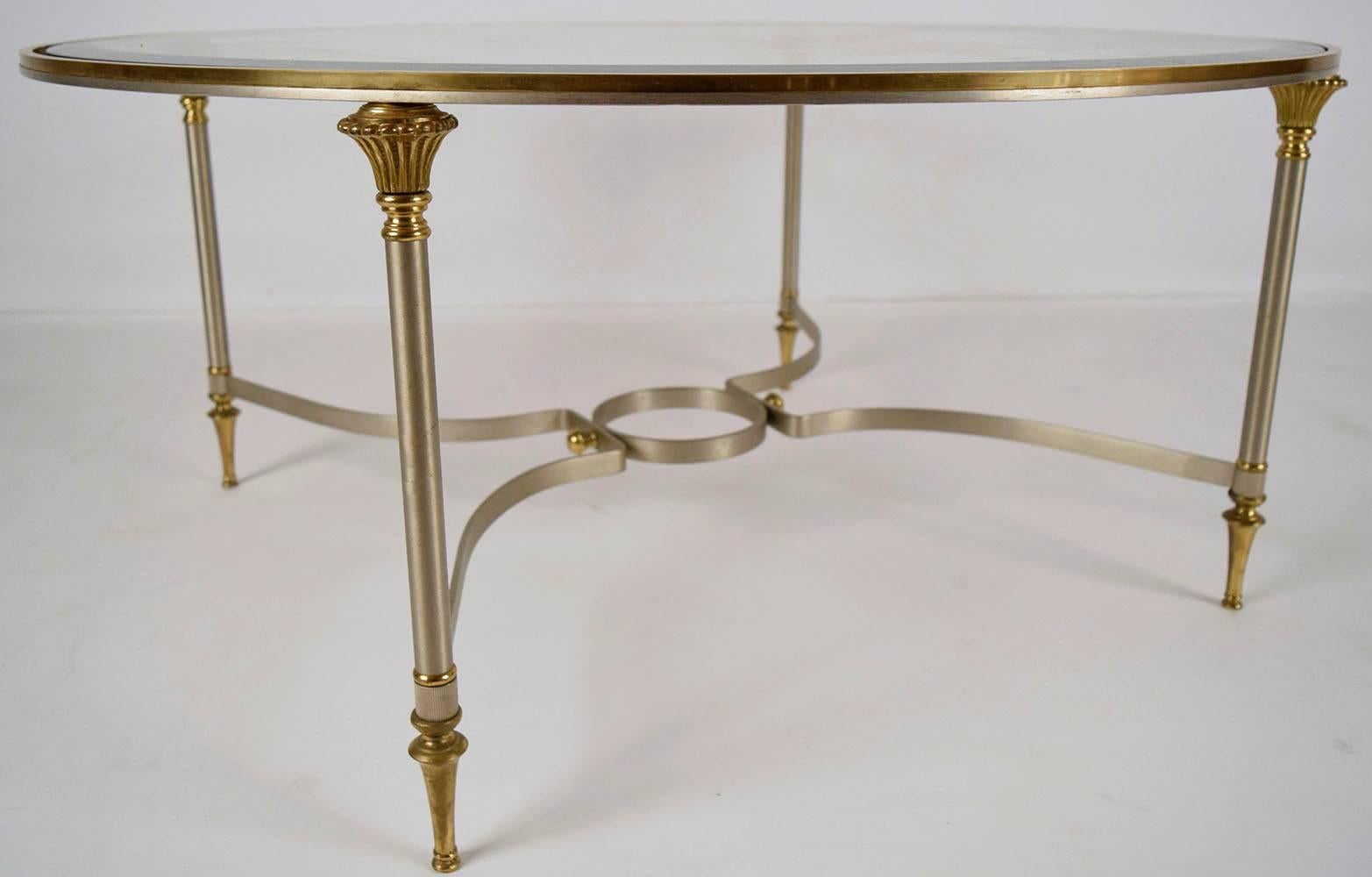 This vintage 1970s Mid-Century circular coffee table features a chrome frame with brass accents on its edges. The 3/8