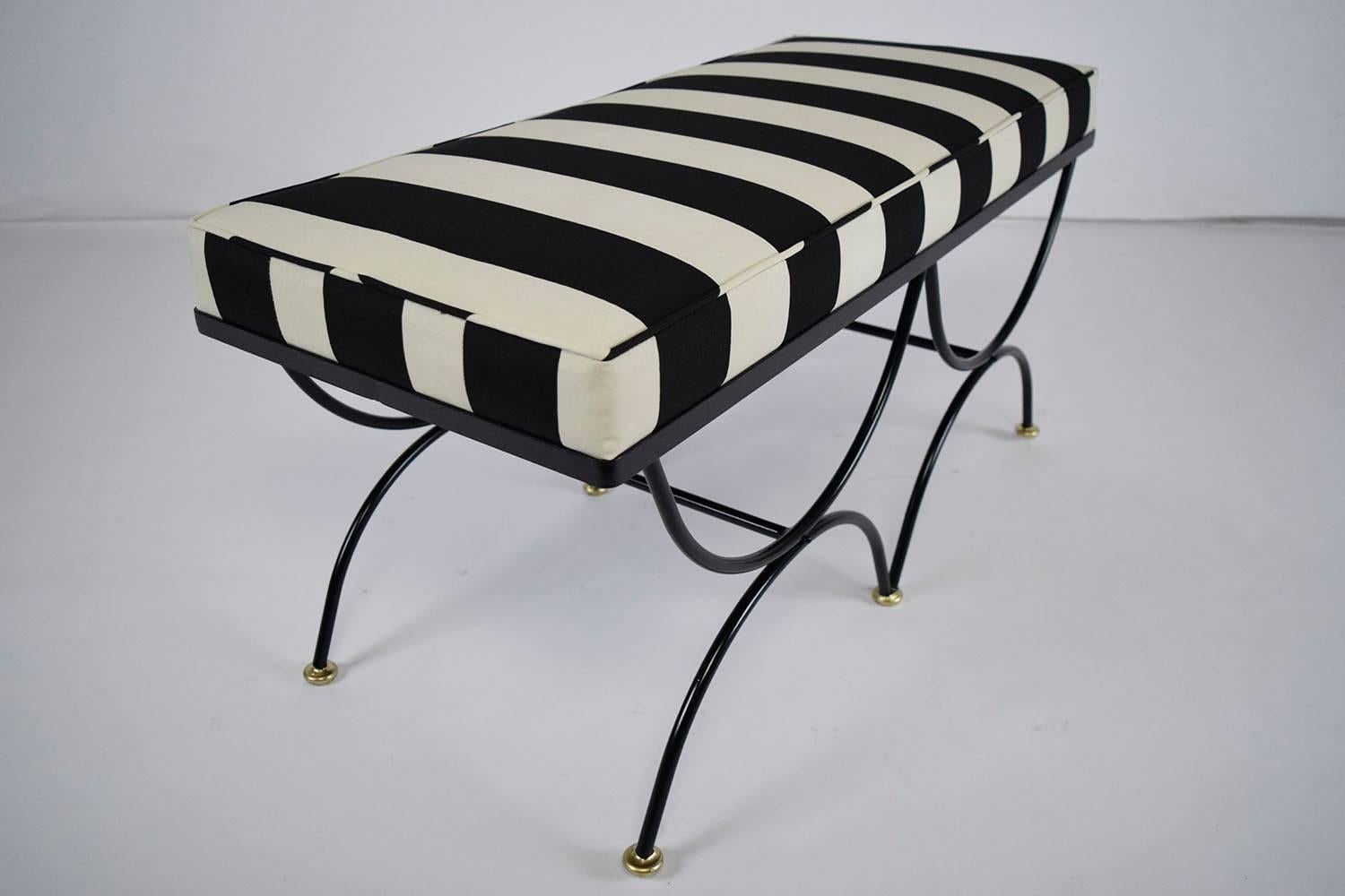 This 1960s Vintage Regency-style bench features iron legs that have recently been painted in a black color with a flat finish. The frame consists of four half circles that are connected by stretcher bars and is finished with round feet. The round