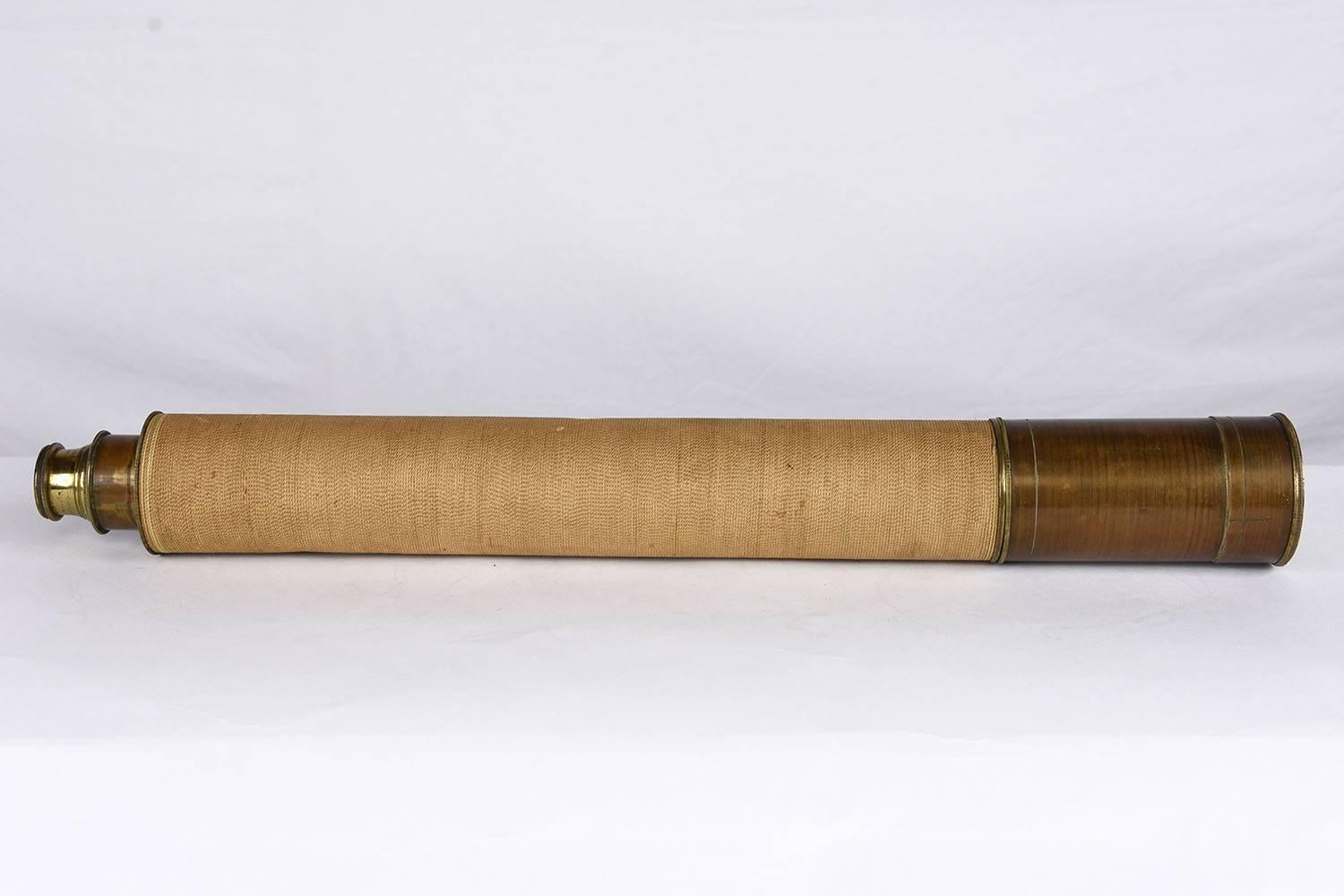 This 1950s vintage Mid-Century Modern nautical spyglass or telescope features a brass tube that has been wrapped in a textile. The spyglass is in working condition with glass lenses. This spyglass is solid, intriguing and ready to be used for years