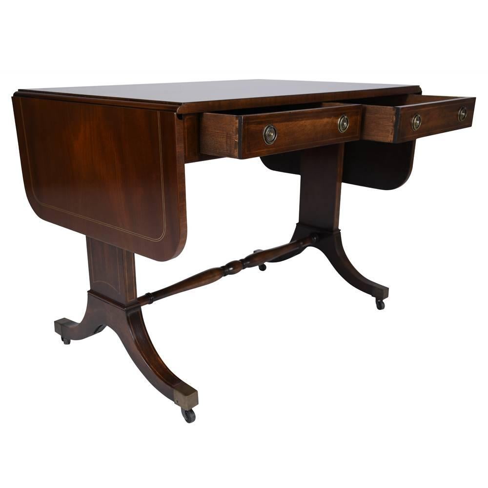 Experience the charm of the 1930s with our English-style sofa table, meticulously crafted from mahogany wood and finished in a medium wood tone with a lacquered finish. This vintage table features two drop leaves on either side that extend to