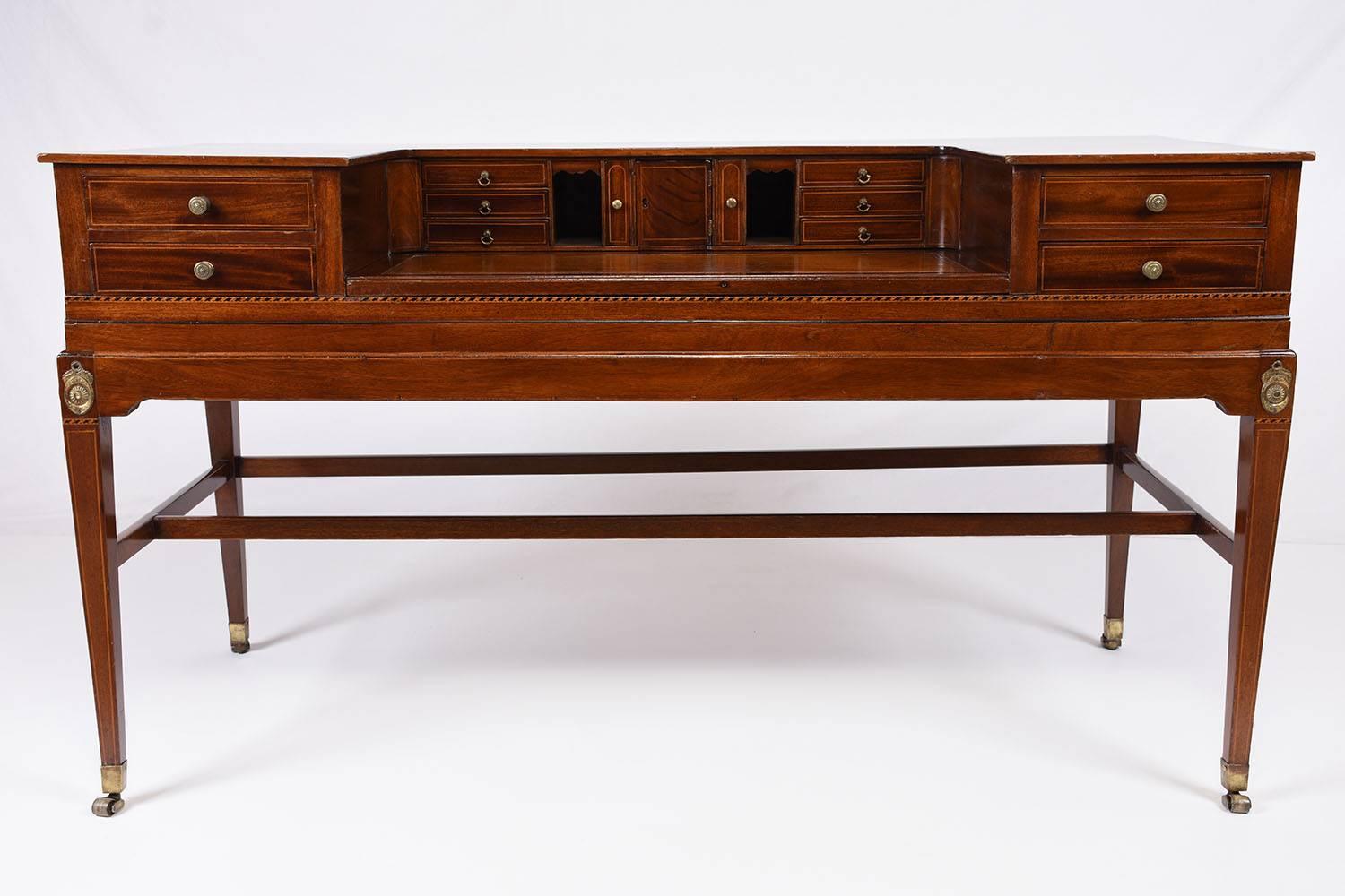 This 1850s antique George III-style Carlton house desk is made of mahogany wood that features its original stain and a new lacquer finish. The writing area is embossed with the original tan colored leather. There are two large drawers on either side