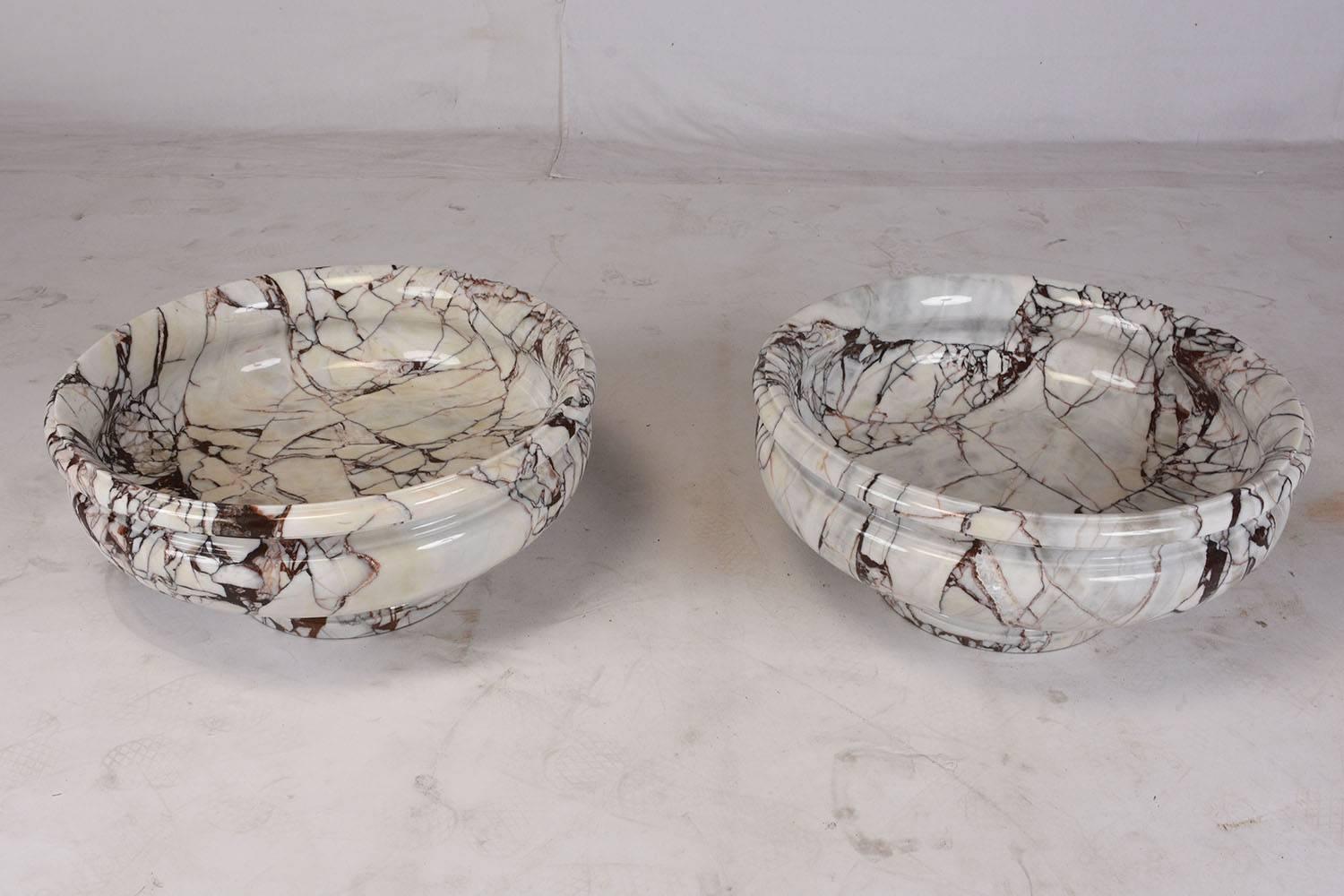 This 1950s pair of French garden urns are made from carved marble in a white color with rouge veins with a polished finish. The elegant architectural details will make these a great addition to any home garden. The urns are in excellent condition