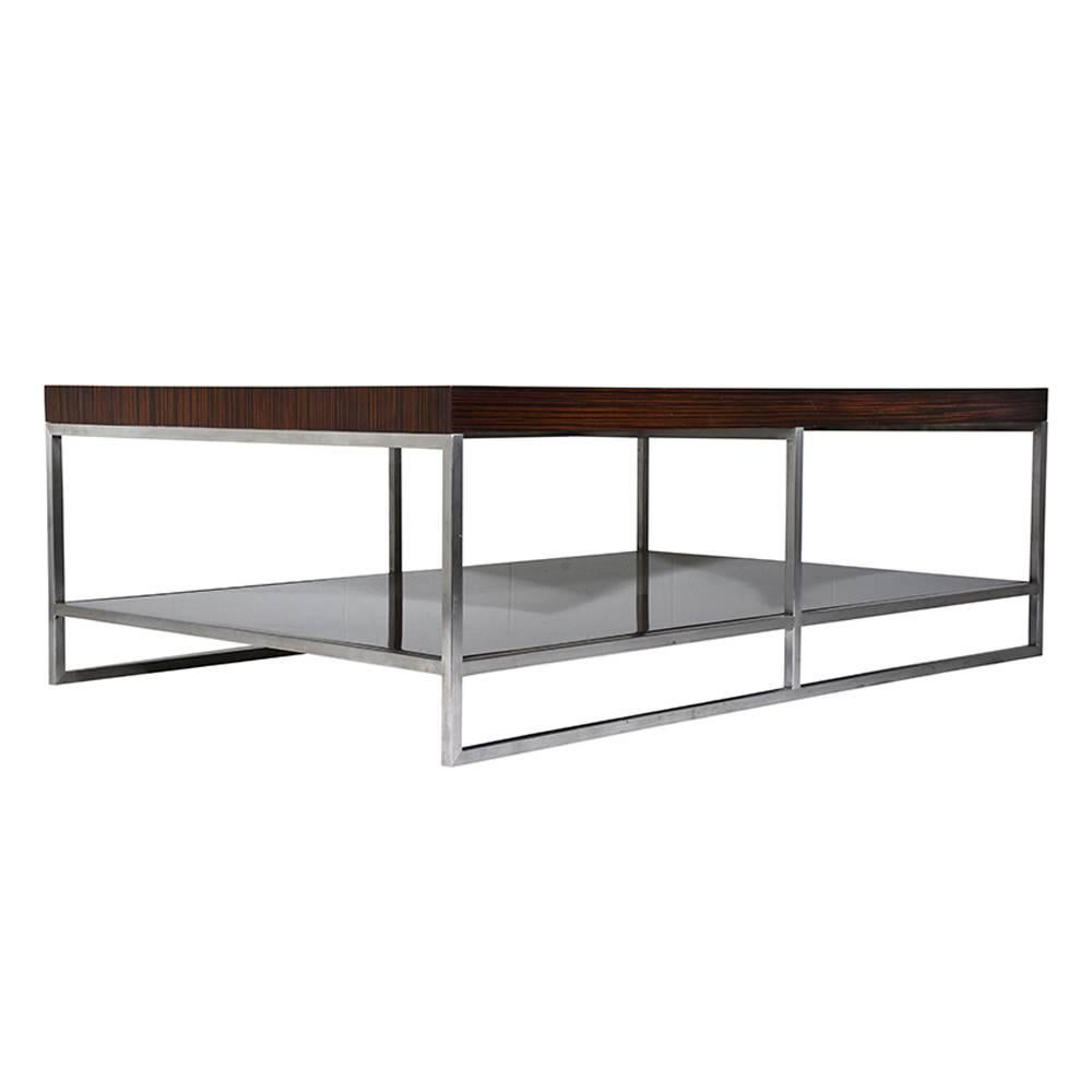 This 1970s Modern-style coffee table is made by Minotti. The top and open shelf is made from macassar ebony and stained in a rich mahogany color and a unique wood grain. The chromed steel frame features geometric shapes. This coffee table is sturdy,