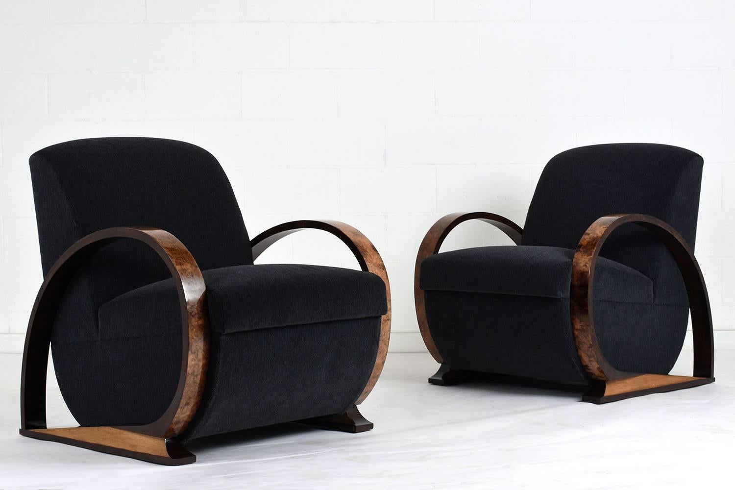 This pair of 1930s French Art Deco-style bentwood armchairs feature two-tone wood frames stained in a light and dark walnut color with a lacquered finish. The unique curve of the armrests are accented by burl wood veneers. The curved bottom of the