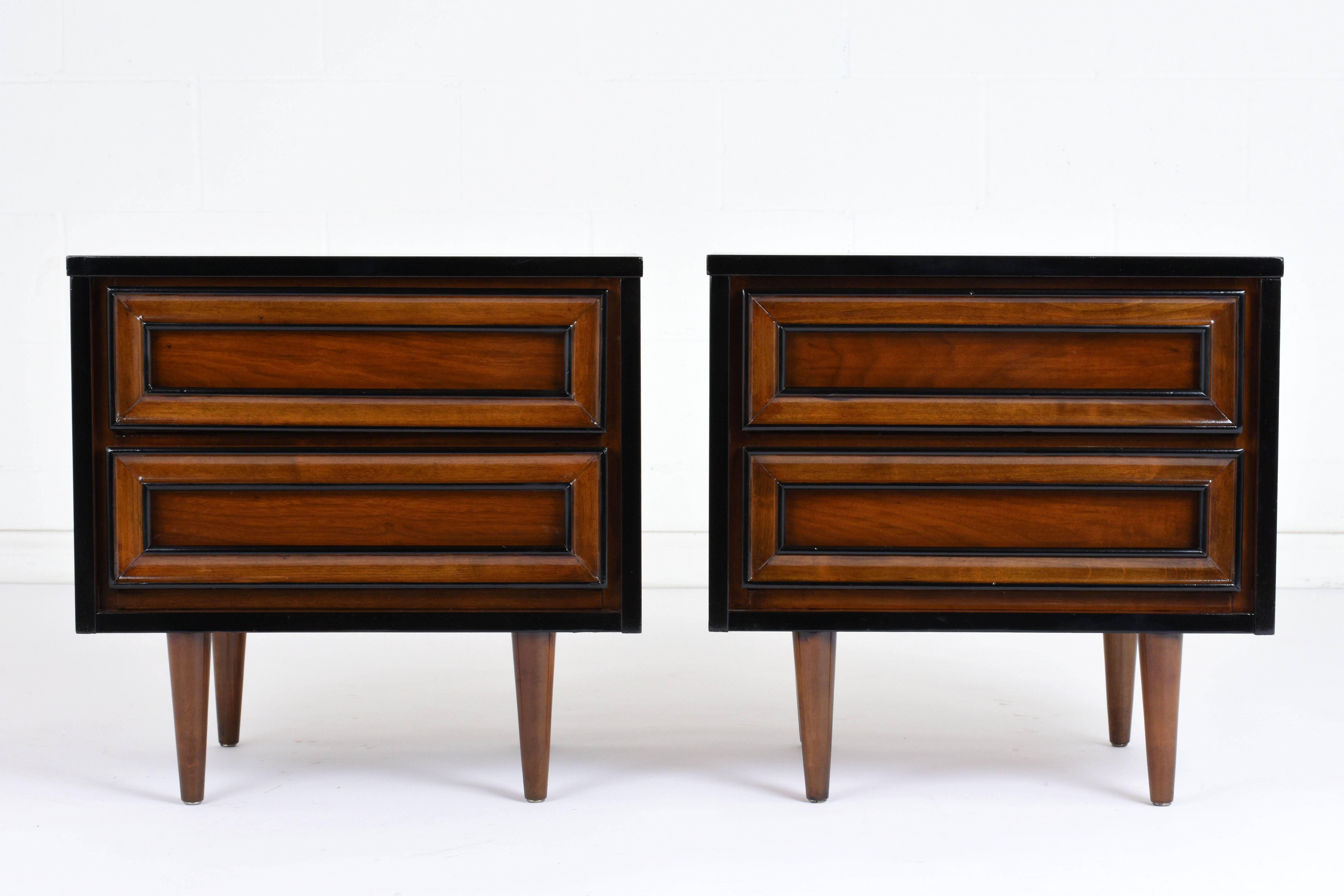 This pair of 1960s vintage Mid-Century Modern style nightstands are made of walnut wood stained in a walnut color with black accents and a lacquered finish. The edges of the nightstands and the moulding on the drawers are painted in a deep black
