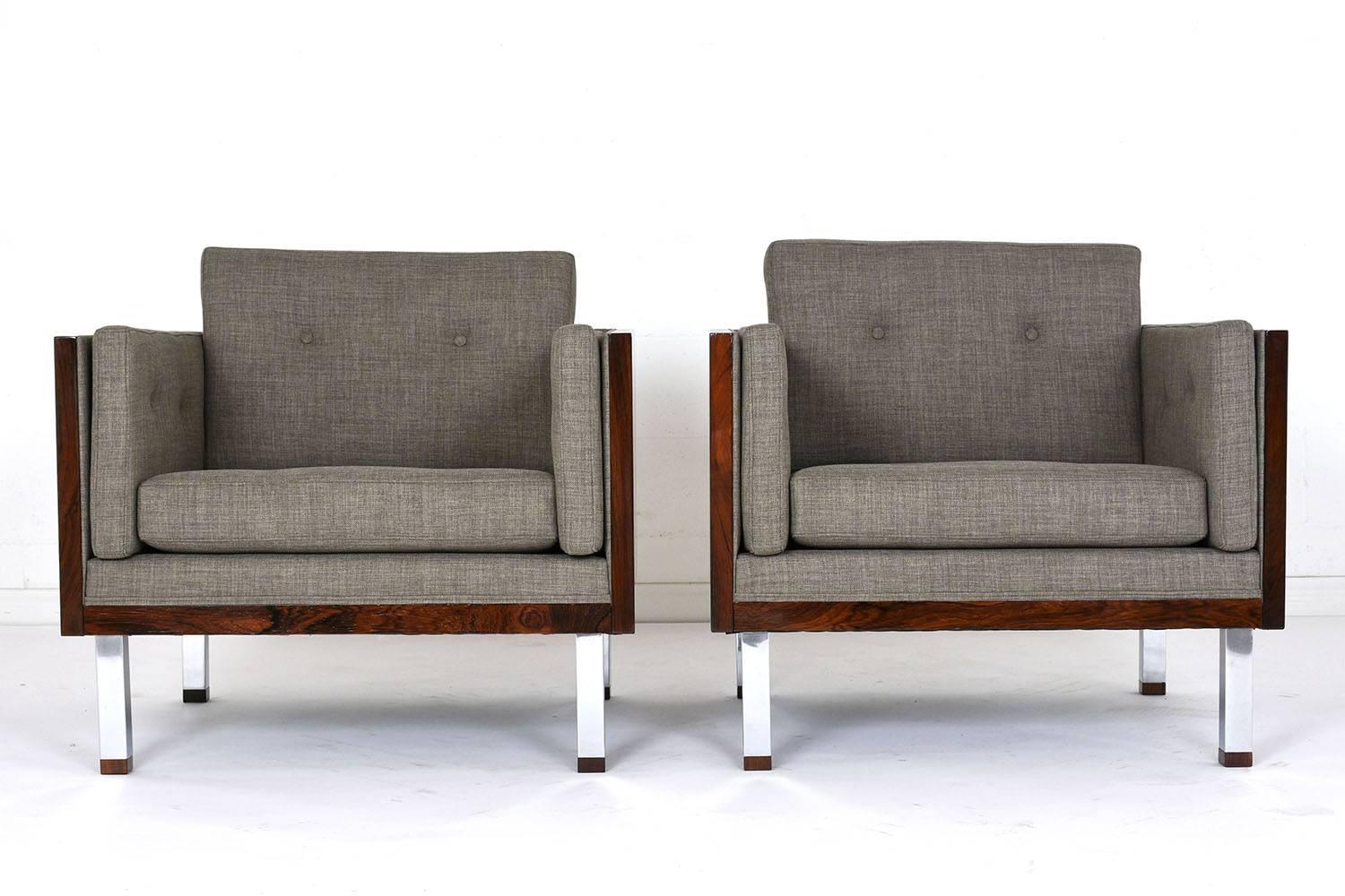 This pair of 1960s Mid-Century Modern-style lounge chairs are designed by Jydsk Mobelvaerk. The cube shape is accented by a rosewood case frame in a rich rosewood color stain and a lacquered finish. The seat has recently been professionally