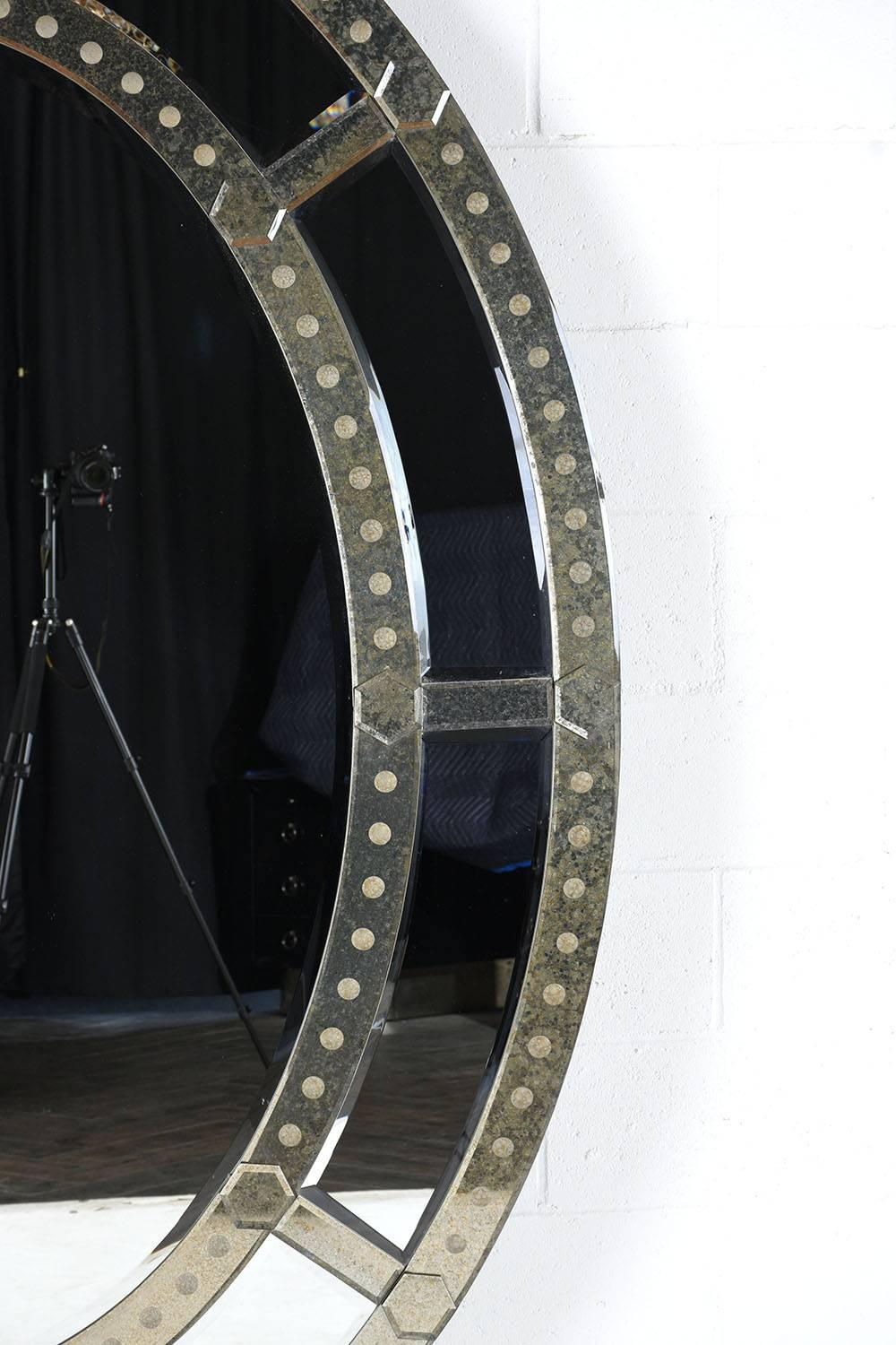 This grand 1980s vintage Venetian-style standing mirror is elegantly oval shaped with a mirrored frame. The frame has a beautiful double bevelled mirrored band with a patina finish. Accenting the mirror bands are decorative dots along the edges