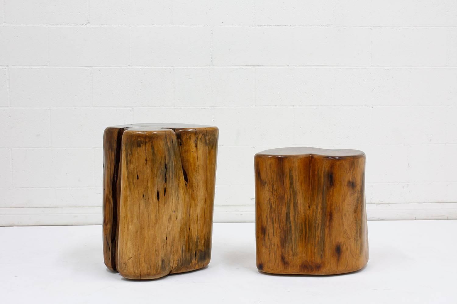 This pair of 1930s organic modern-style side tables or stools are made from walnut wood stumps. The stumps are feature a natural stain with a polished finish. The organic shape of the stumps are unique and timeless. This pair of side table or stools