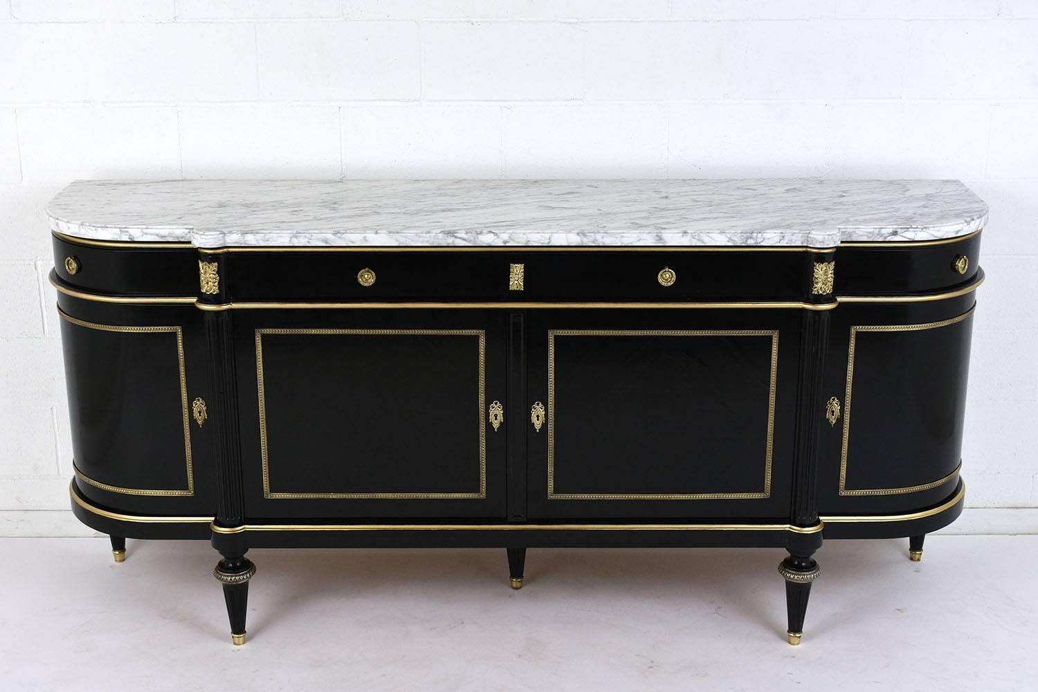 This 1900s French Louis XVI-style buffet is made of mahogany wood with an ebonized and lacquered finish. The buffet features an elongated demilune shape with four cabinets and drawers. The buffet is adorned with brass rosettes and moulding details