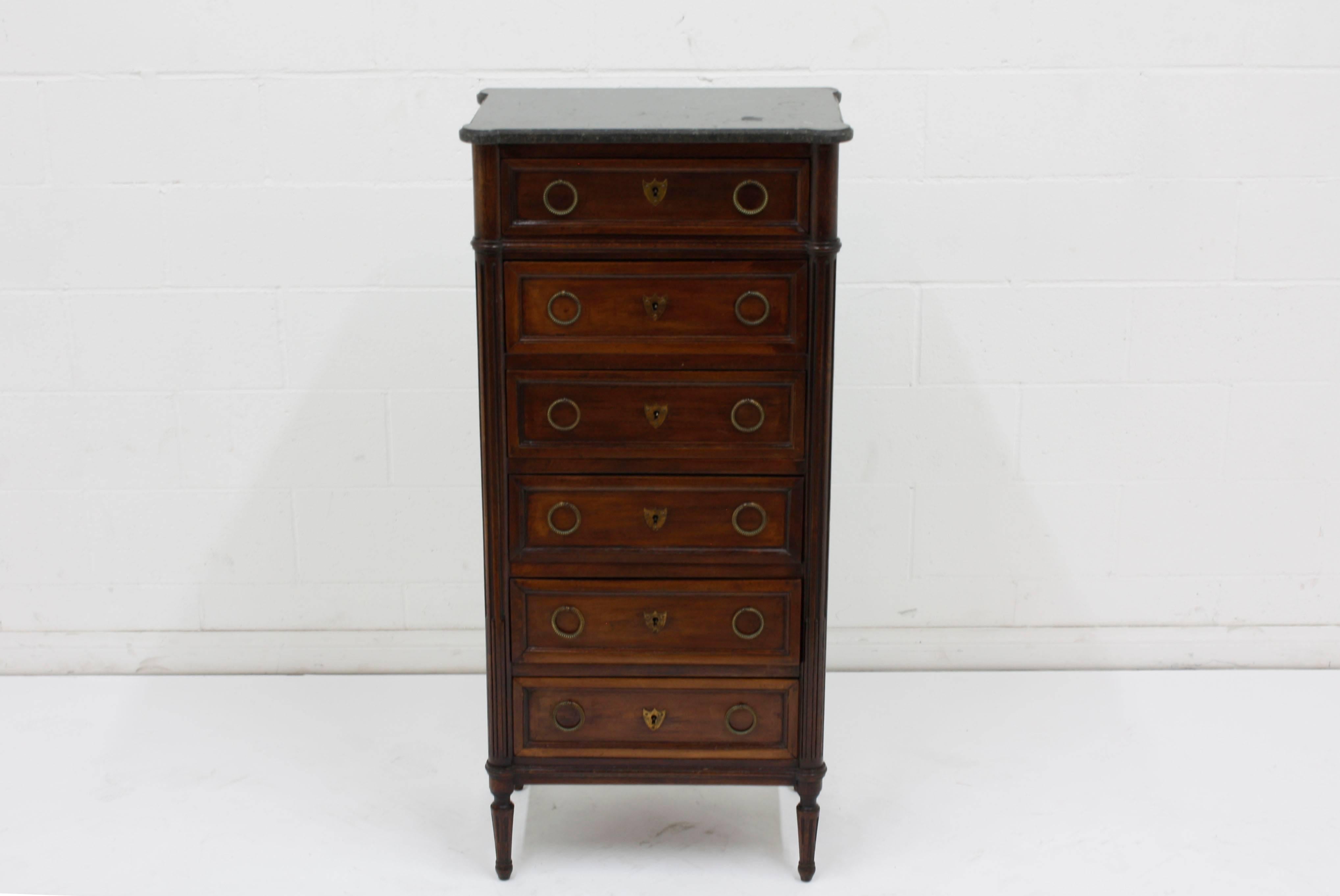 This 1890s French Louis XVI-style chest of drawers is made of walnut wood stained in a rich walnut color with a lacquered finish. This chest has six drawers adorned with moulding and brass drawer pulls and keyhole plates. The corners of the chest