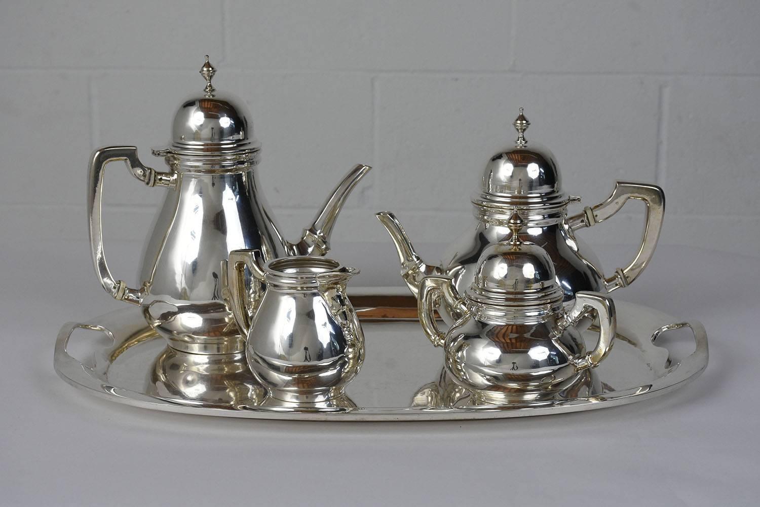 This five-piece Tiffany-style tea set is made of sterling silver stamped .925 and is a host's dream. The set includes a coffee pot, tea pot, milk jar, sugar dish, and serving platter. The tea set features a Classic and timeless design and clean