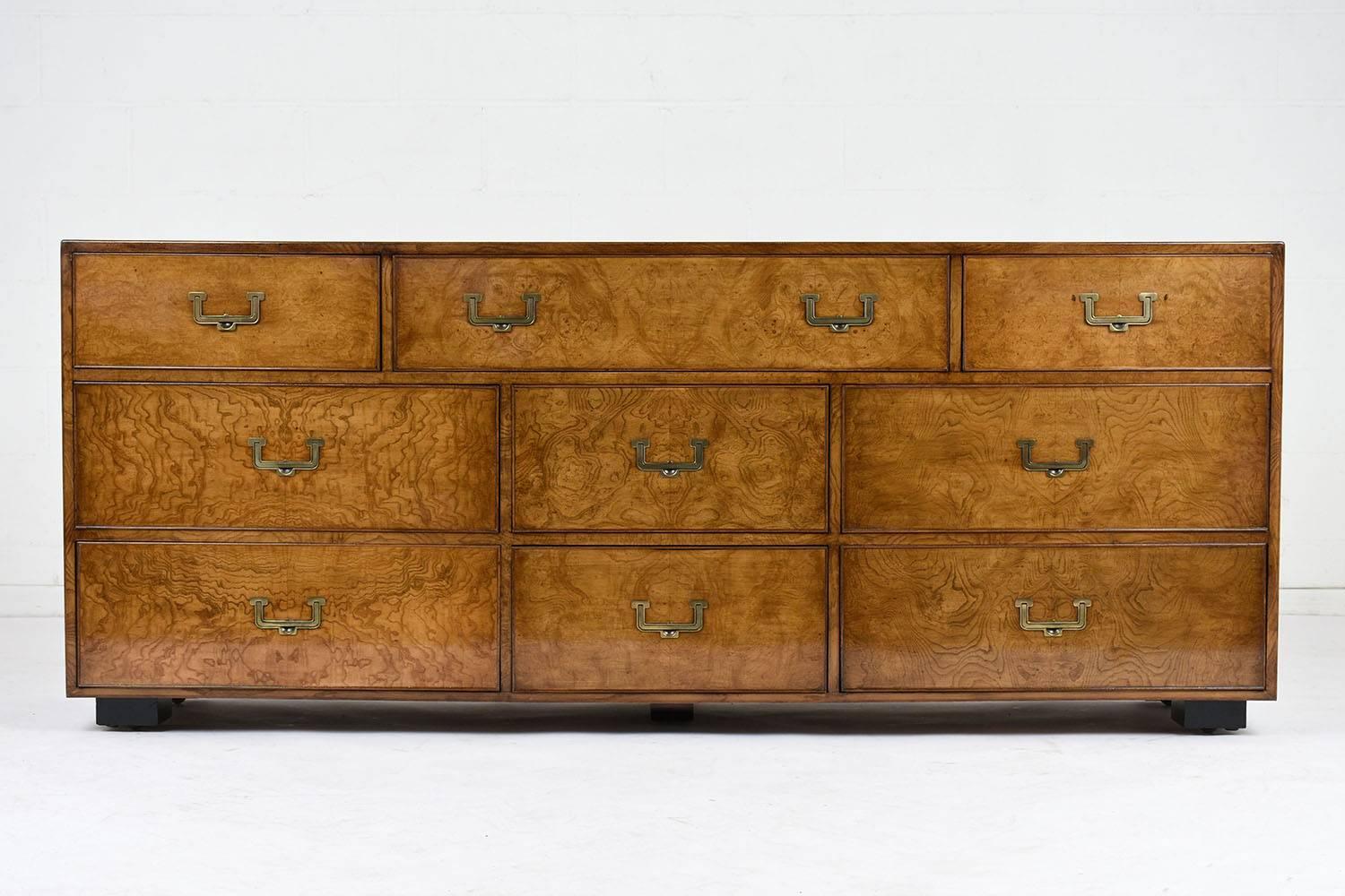 This 1960s modern style chest of drawers is made by John Widdicomb. The nine-drawer chest is covered in birch wood veneers stained in a rich light walnut color and a lacquered finish. The drawers have a delicate moulding accent along the edges with