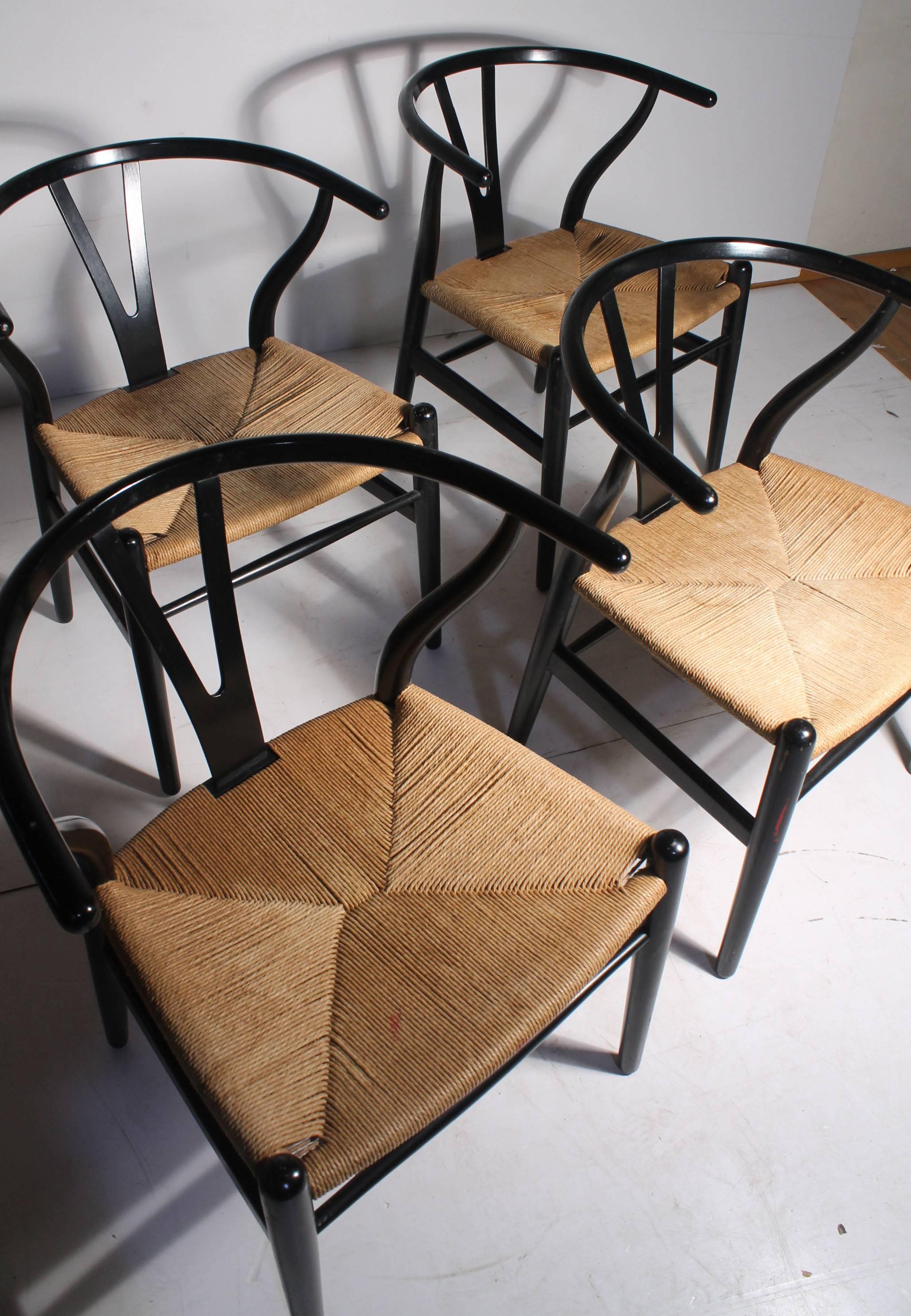 A nice set of vintage Wegner wishbone chairs in black. They retain the paper label under the seat. Vintage wear. Please contact for condition report and additional photos.