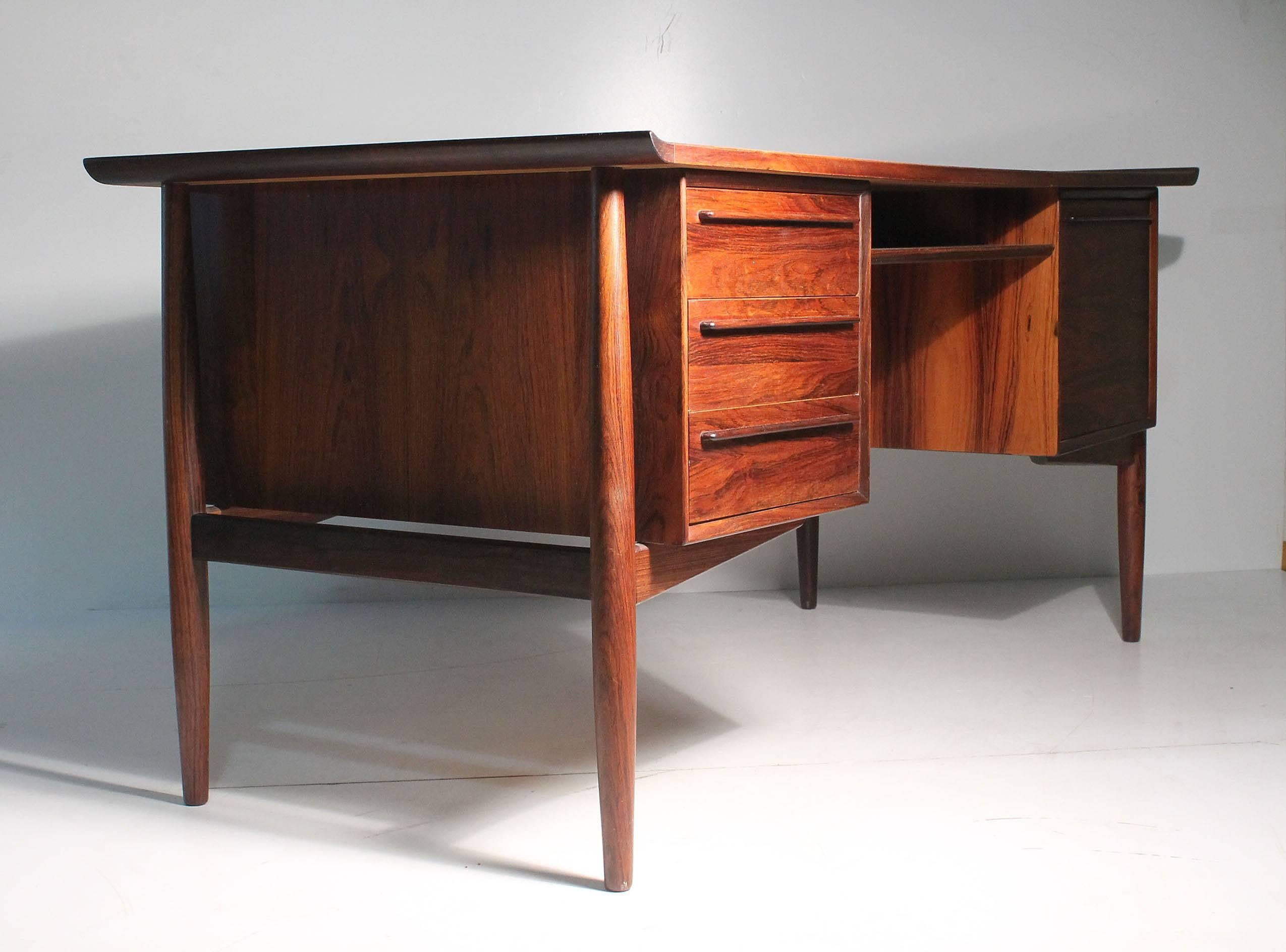 Exceptional Arne Vodder rosewood executive desk.

Comes with one adjustable and removable rosewood shelf to be inserted on backside space (not photographed).