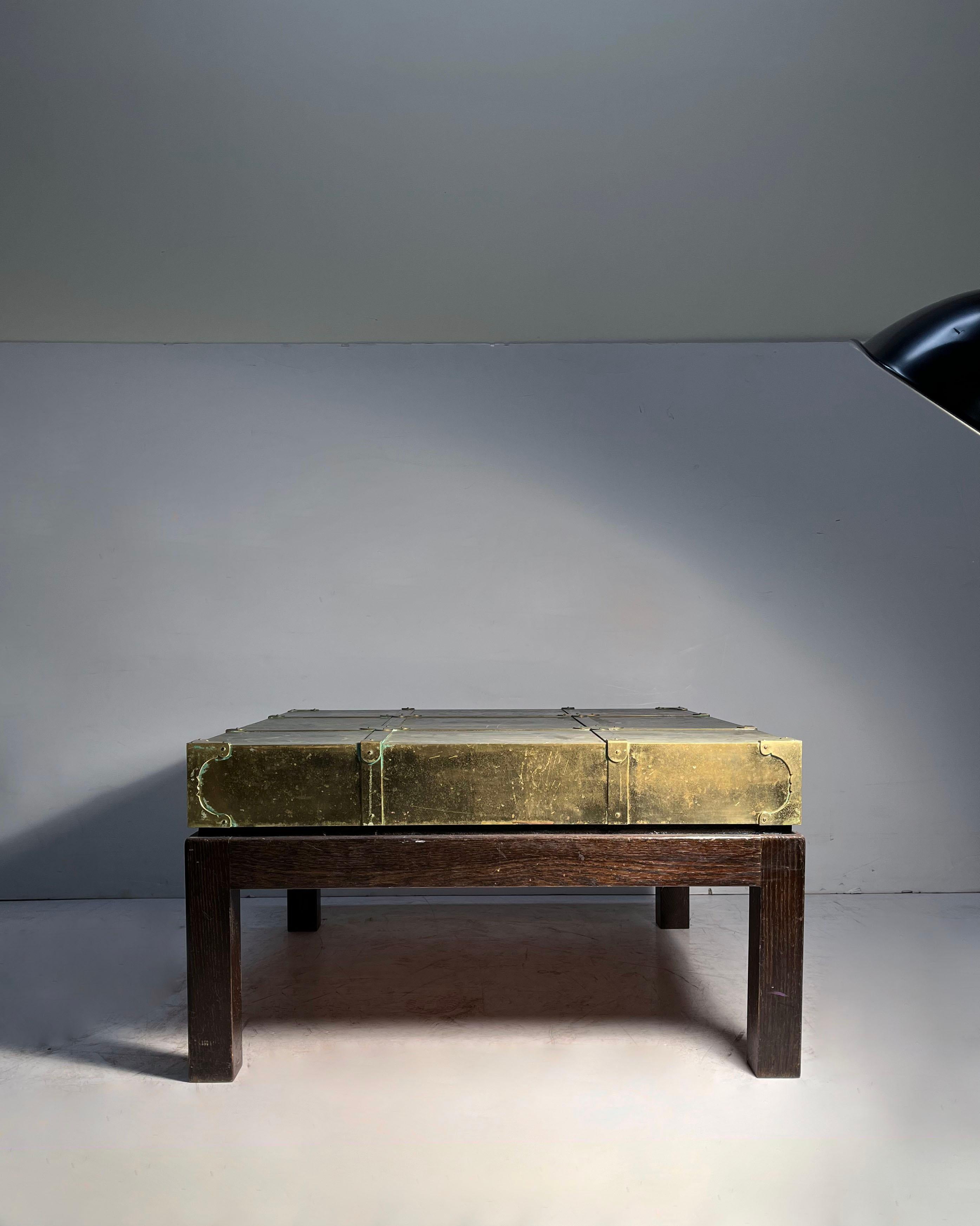 A Campaign Style Brass Coffee / Side Table by Sarreid

Plenty of wear and Patina to the brass as shown.  These usually clean up beautifully as they are brass. or can be left as is in an aged patina state. 

Wood Parsons base has wear to finish and
