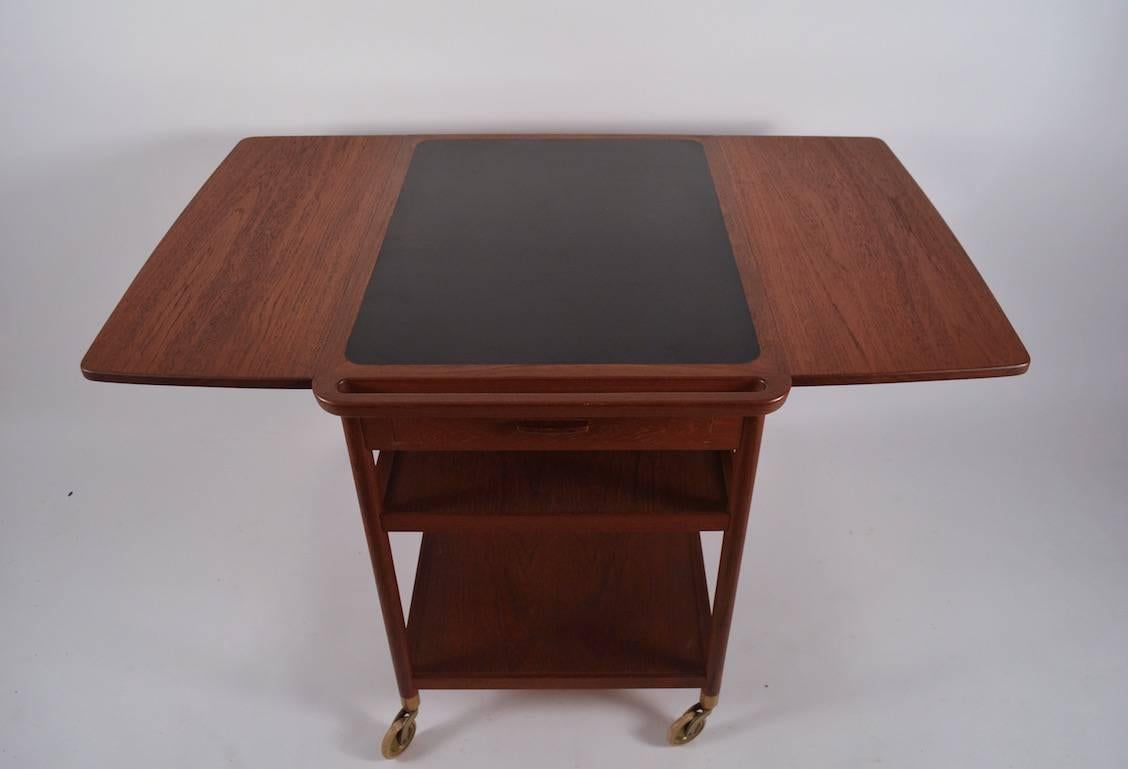 Nice period example, in very fine original condition. Teak with black laminate top, marked 