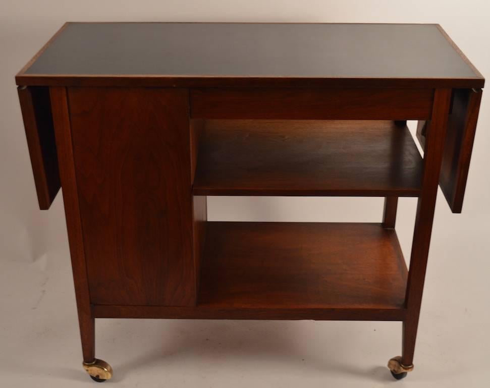 Well-made serving cart, with two drop leaves, storage cabinet and drawer. 
Measures: Width closed 38.5