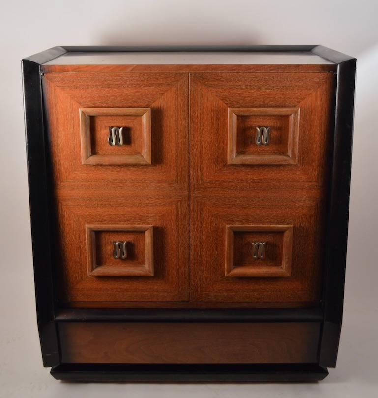 Substantial solid mahogany dresser having cerused finish with fading black trim. The finish (original) shows some wear, and poor touch ups (see profile view).
The front doors open to reveal six interior drawers, the base is also a large drawer.