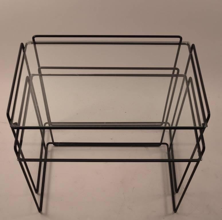 Two-piece nest of tables, wrought iron rods in black with original glass tops. Design by Max Sauze, very good original condition. Dimensions in listing are for the larger table, shelf height 20