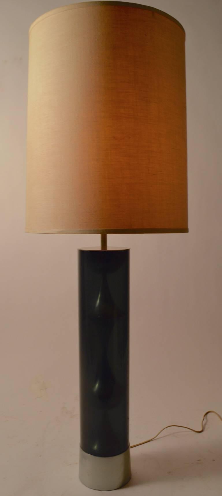 This table lamp features a dark smoked Lucite tube which houses a decorative chrome element. The lamp included the original shade, which shows minor wear. Working, original and clean condition, 23