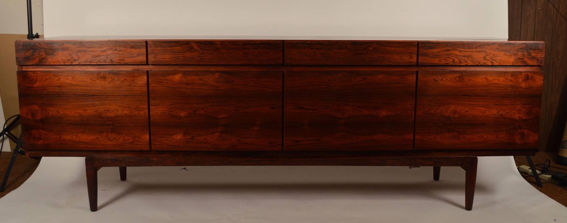 Four drawers over four doors, which open to shelved storage, and five slide out interior drawers. Perfect as a server, credenza, console or dresser. The top shows a slight variation in tone, as something rested on the surface for decades, as shown