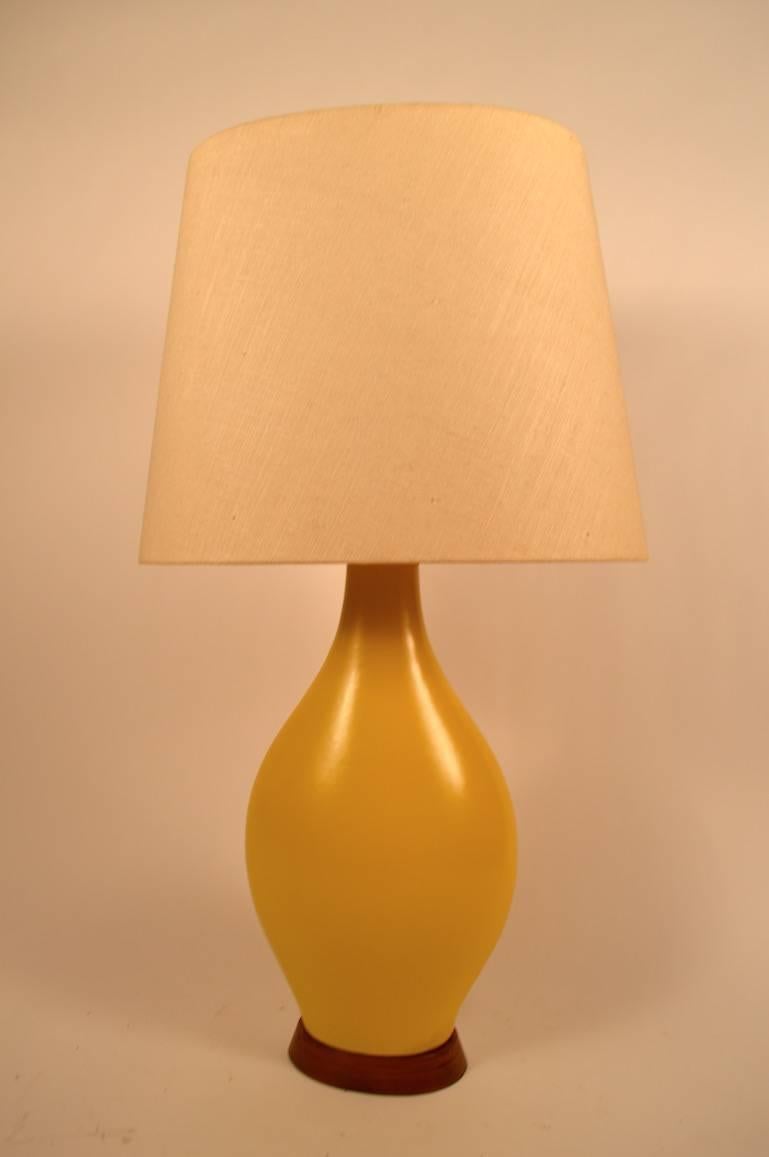 Classic Mid-Century Modern teardrop form, yellow ceramic table lamp, mounted on original solid wood base, with original shade. Great, working condition, clean, ready to use. Dimensions in listing are for the lamp body, shade is 19.5