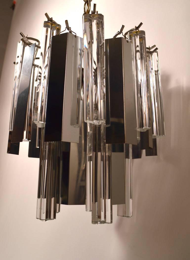 This chandelier has both triangular glass and chrome hanging elements making it highly reflective and bright. Some glass shades have internal cracks, common for this type of chandelier. All shades are intact and usable. Fixture takes one standard