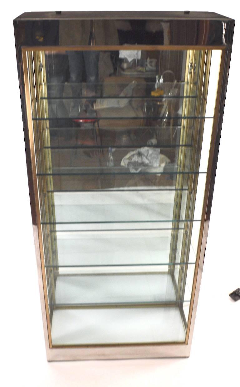 Wonderful quality chrome, brass and glass light up vitrine (Lights top and or bottom). Five thick plate glass shelves rest on adjustable pegs (10