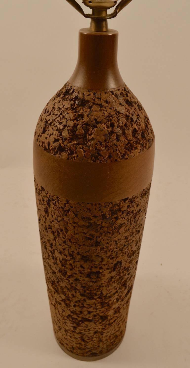 Lampe de table en forme de bouteille en liège et bois en bon état de fonctionnement d'origine. L'abat-jour n'est pas inclus. Mesures : Hauteur jusqu'au sommet de la prise 25