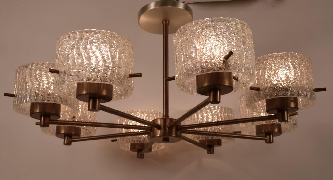 Brass spoke form chandelier, with textured glass shades. Each cylindrical glass shade is 3.5