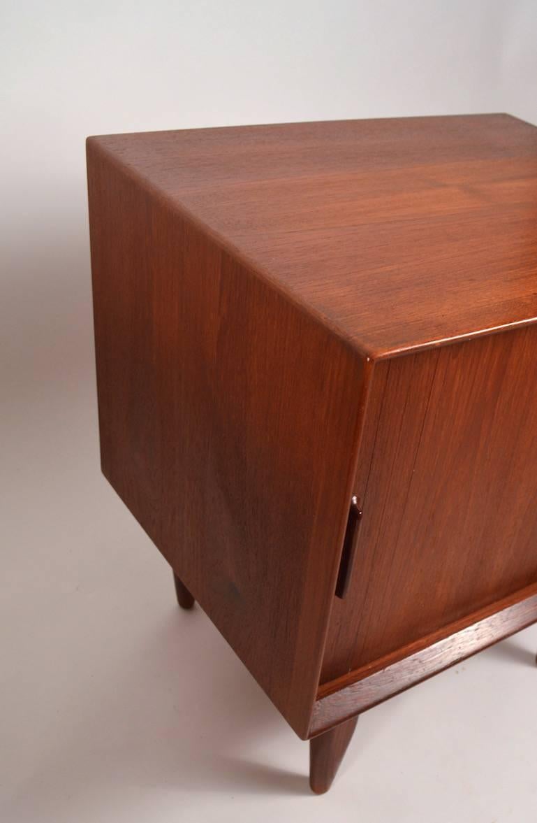 Pair of Danish modern teak nightstands, with tambour roll front - opens to reveal one drawer over shelved open storage.
